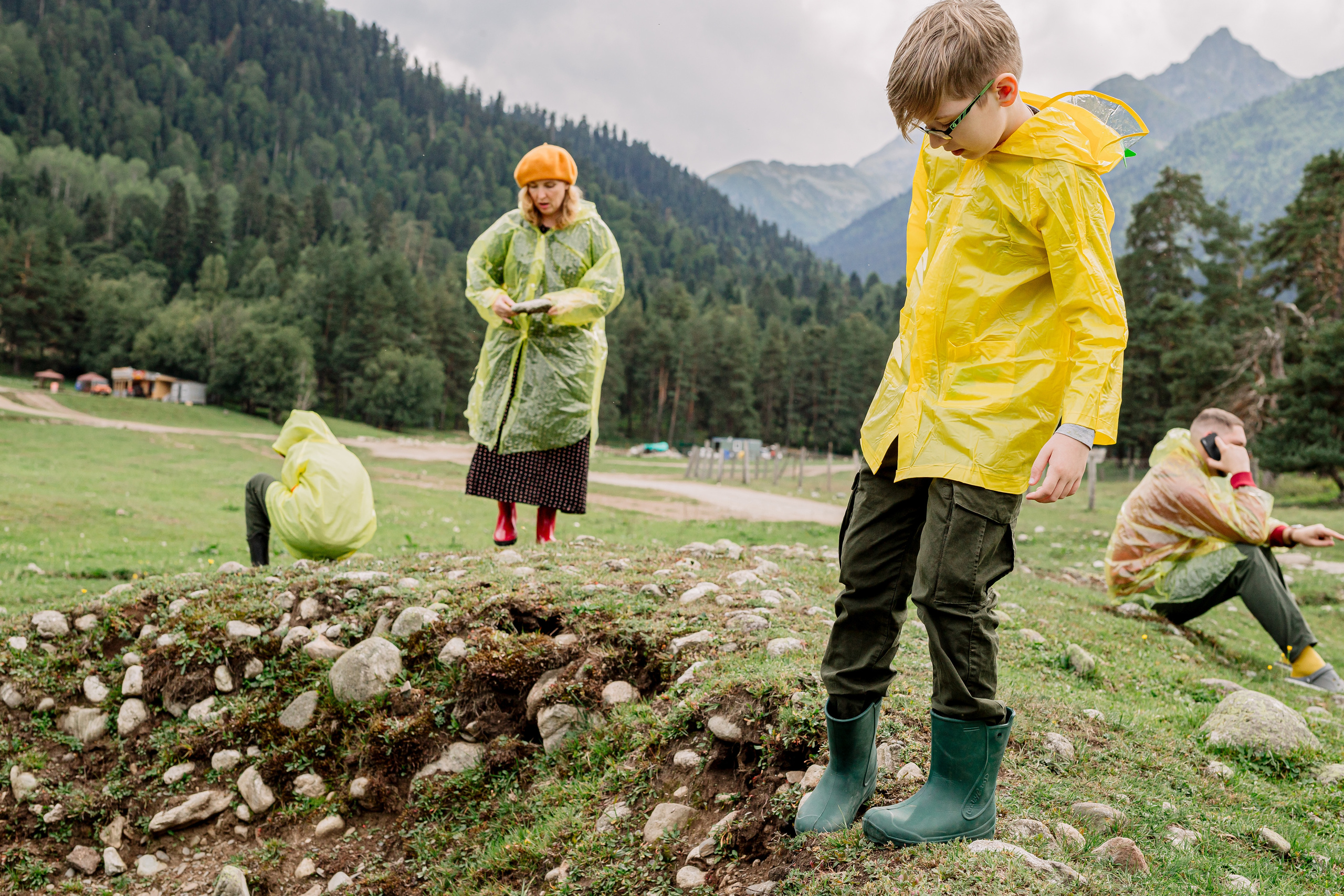 Архыз, горы, лес, семейная съемка в горах, Выездная съемка, фотограф на выезд, семейный фотограф в Астрахани, семейный фотограф,  семейный портрет в горах под дождем, семейный портрет в дождевиках. фотосессия в дождевиках