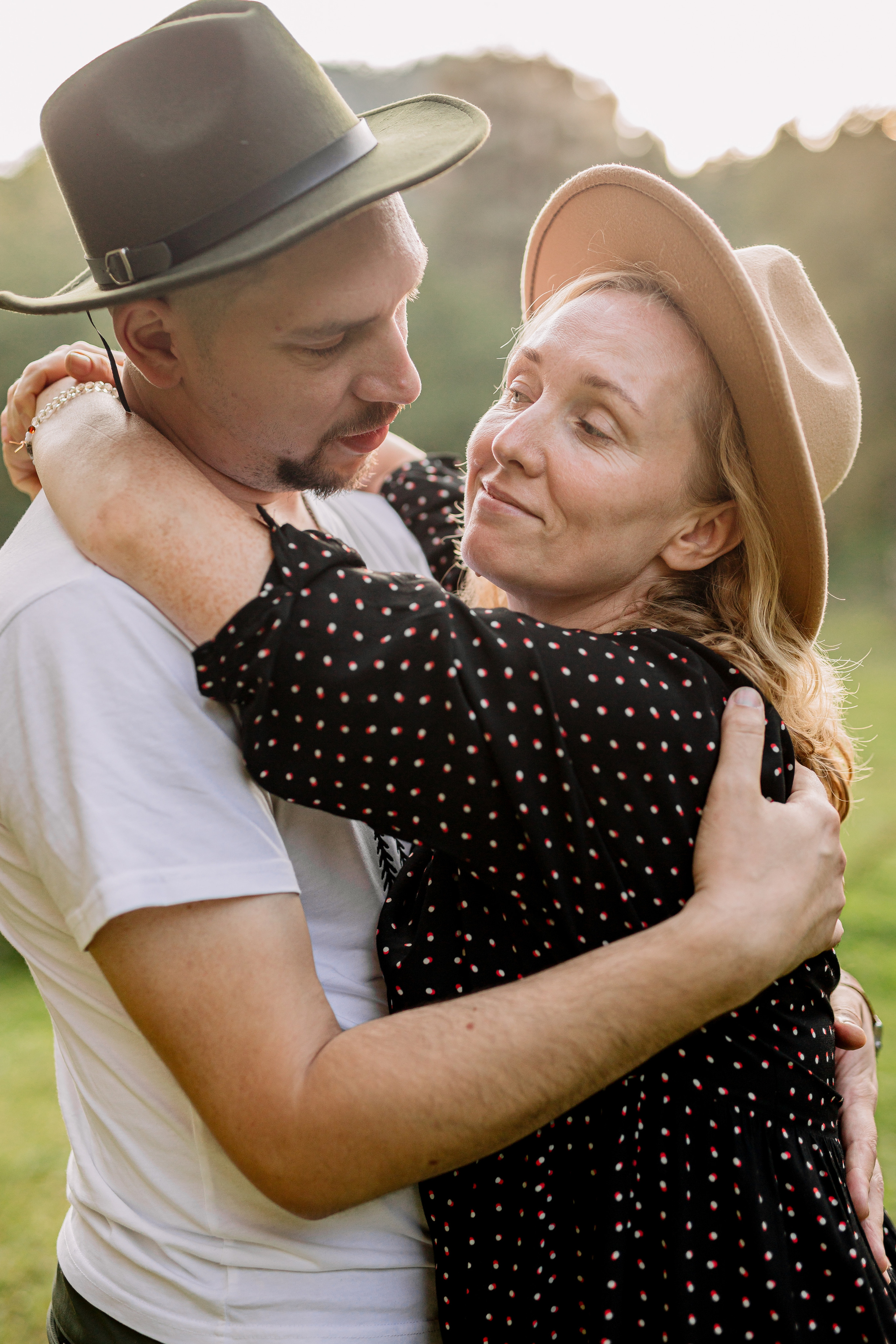 Архыз, горы, лес, семейная съемка в горах, Выездная съемка, фотограф на выезд, семейный фотограф в Астрахани, семейный фотограф,  семейный портрет в горах пара в шляпах обнимается на закатном солнце