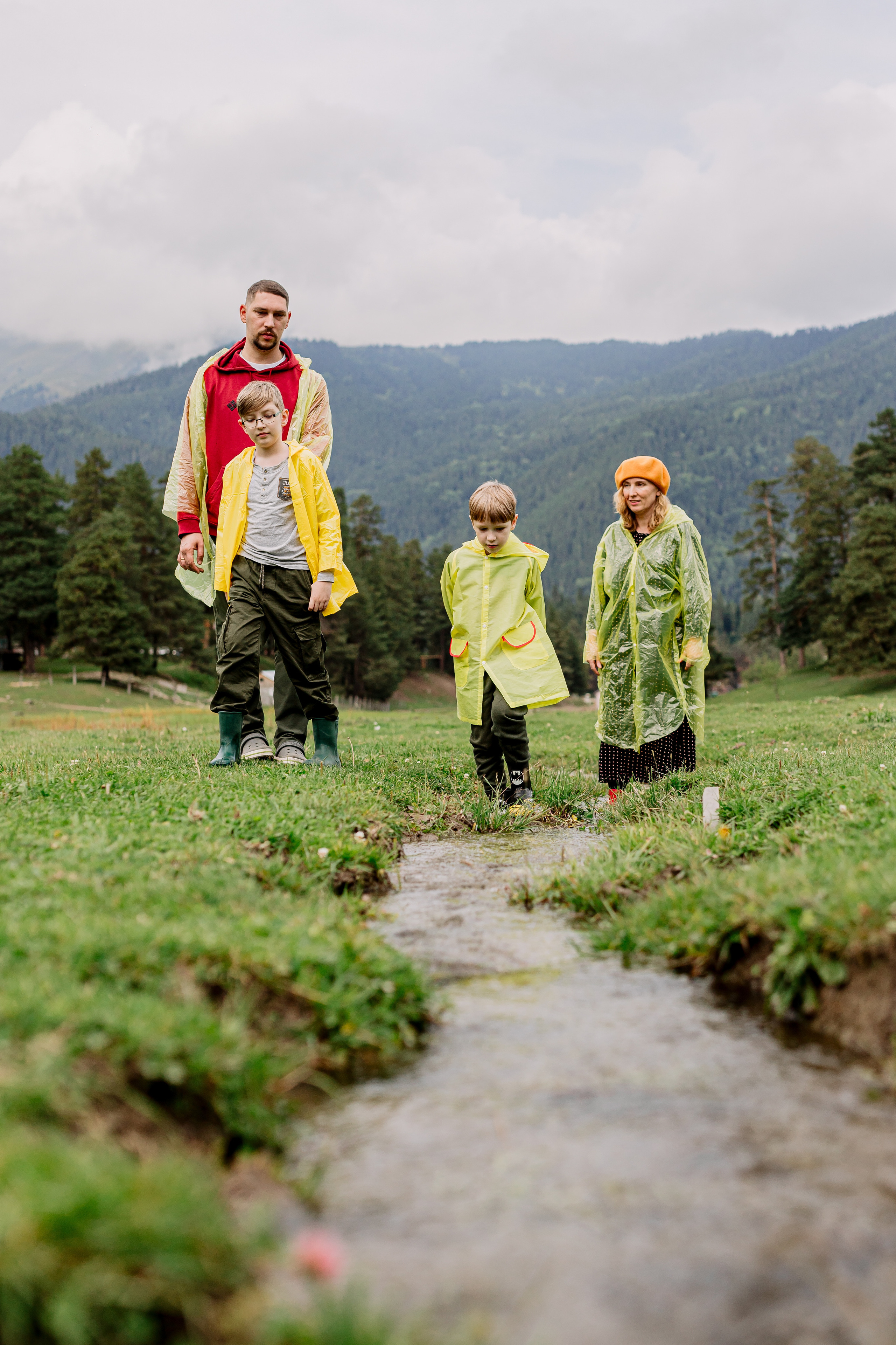 Архыз, горы, лес, семейная съемка в горах, Выездная съемка, фотограф на выезд, семейный фотограф в Астрахани, семейный фотограф,  семейный портрет в горах под дождем, семейный портрет в дождевиках. фотосессия в дождевиках