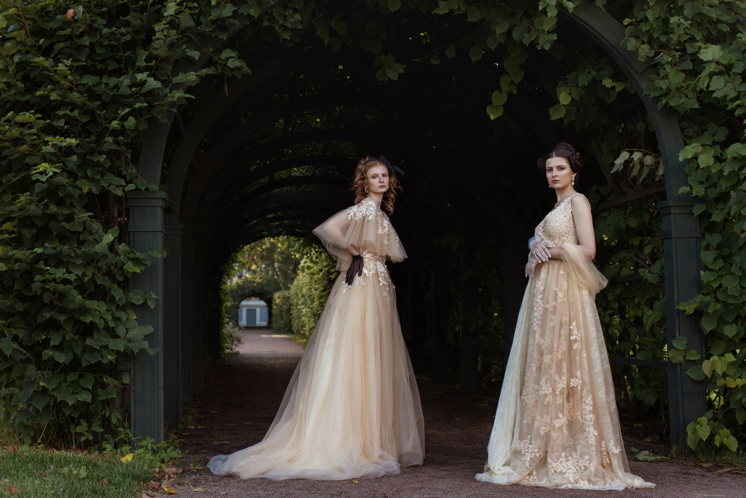 Фотосессия девушек в Кусково в костюмах и с прическами XIX века на фоне арки и стены из зелени 