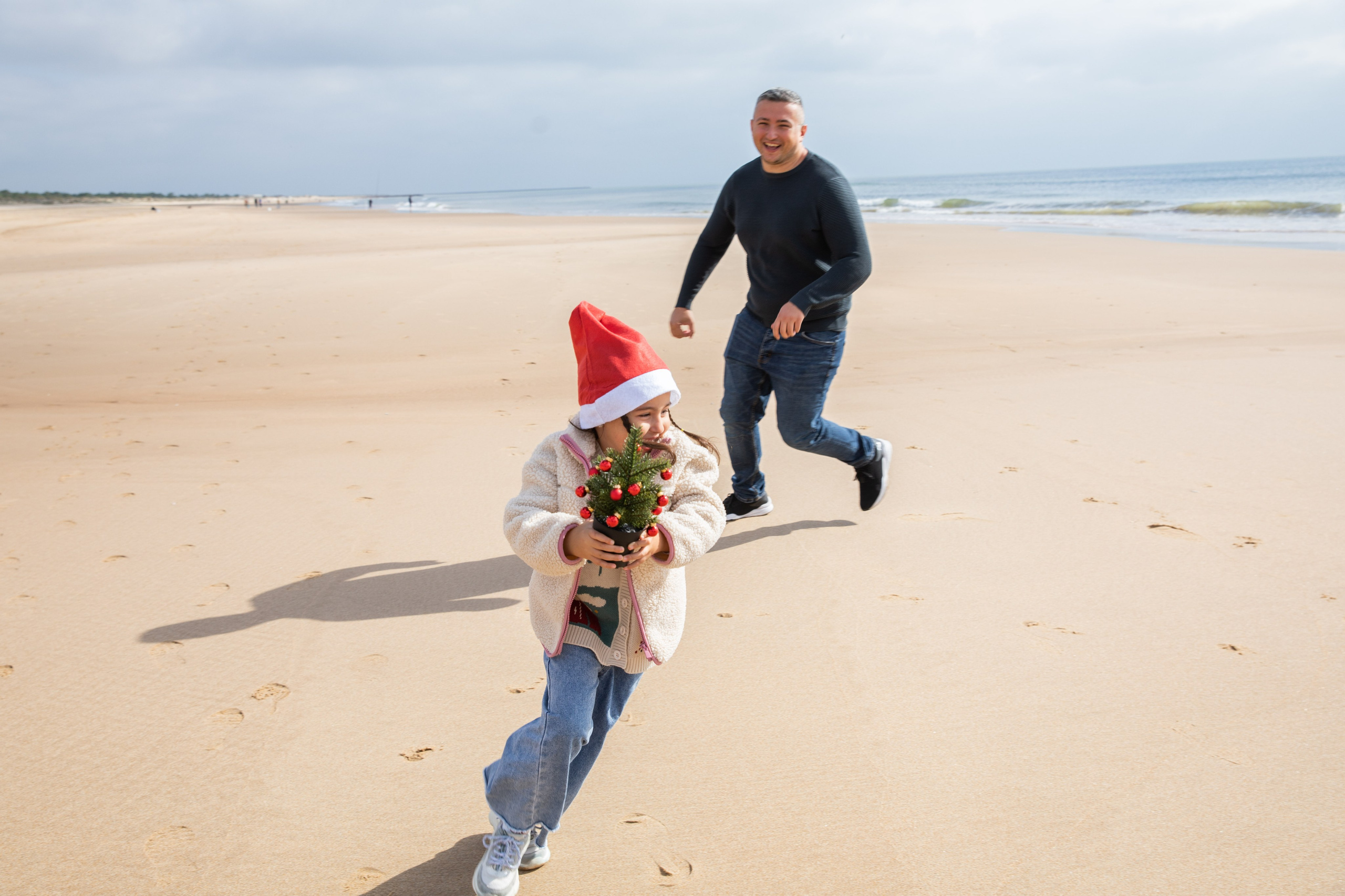 A joyful moment by the ocean, as the family plays on the shore