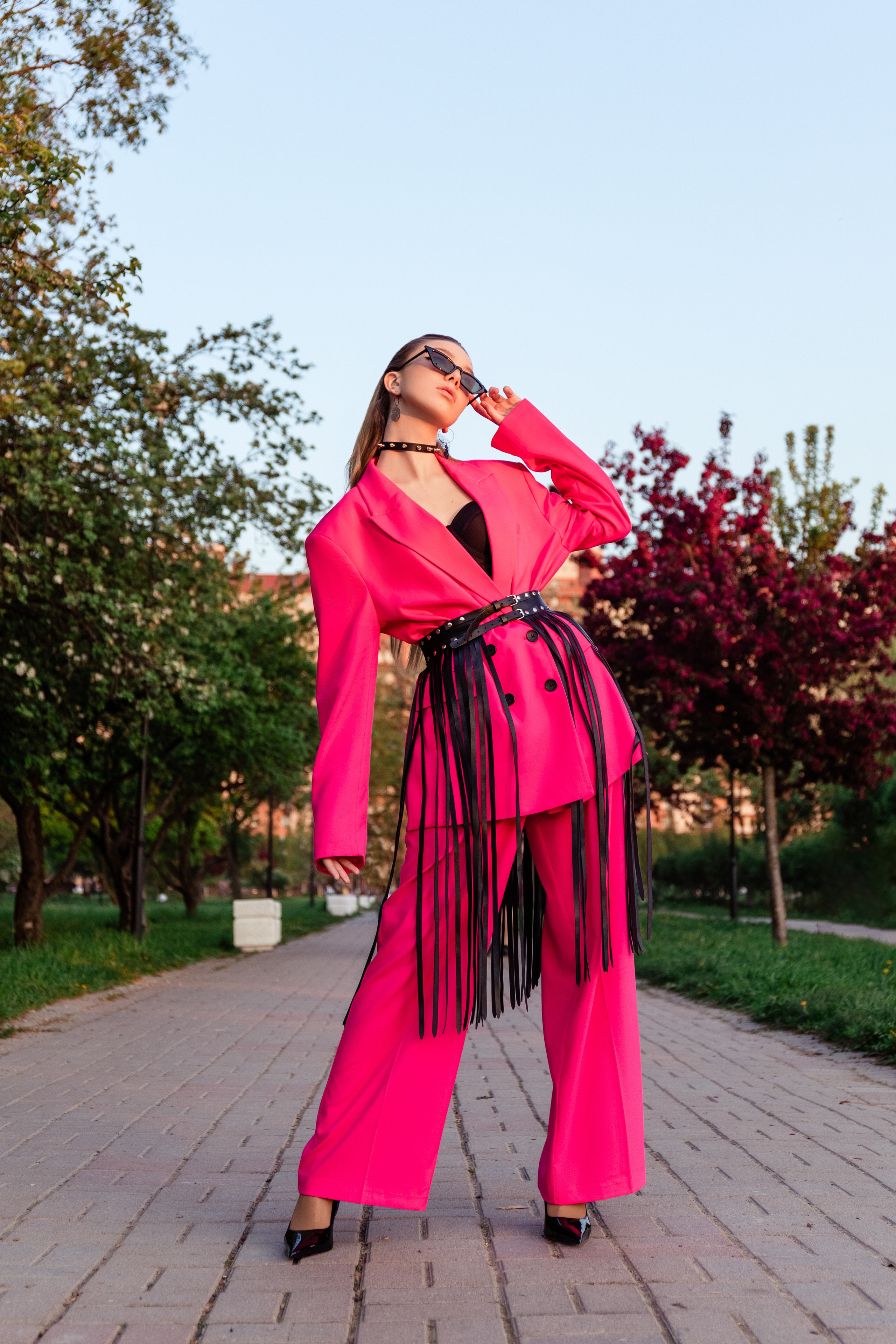 Фотография девушки в розовом костюме на аллее