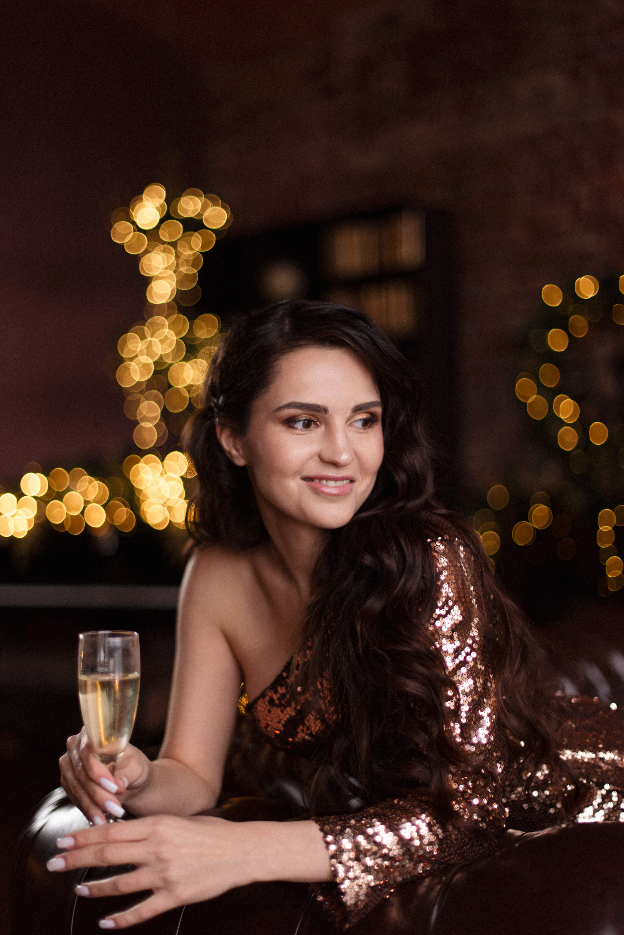 Магия Нового года: девушка в сверкающем бронзовом платье в лофте.