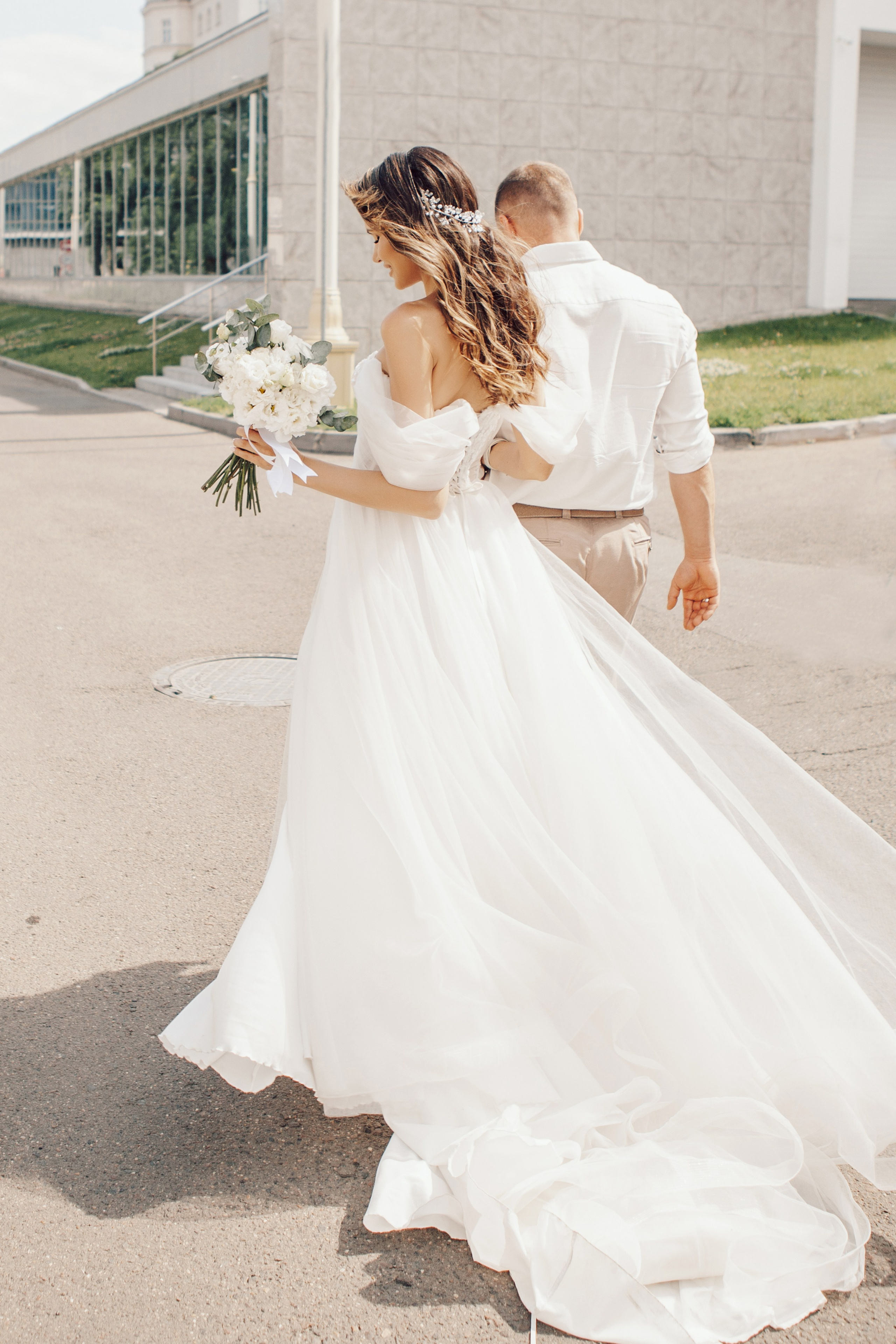 Красивый шлейф на свадебном платье развивается на ветру