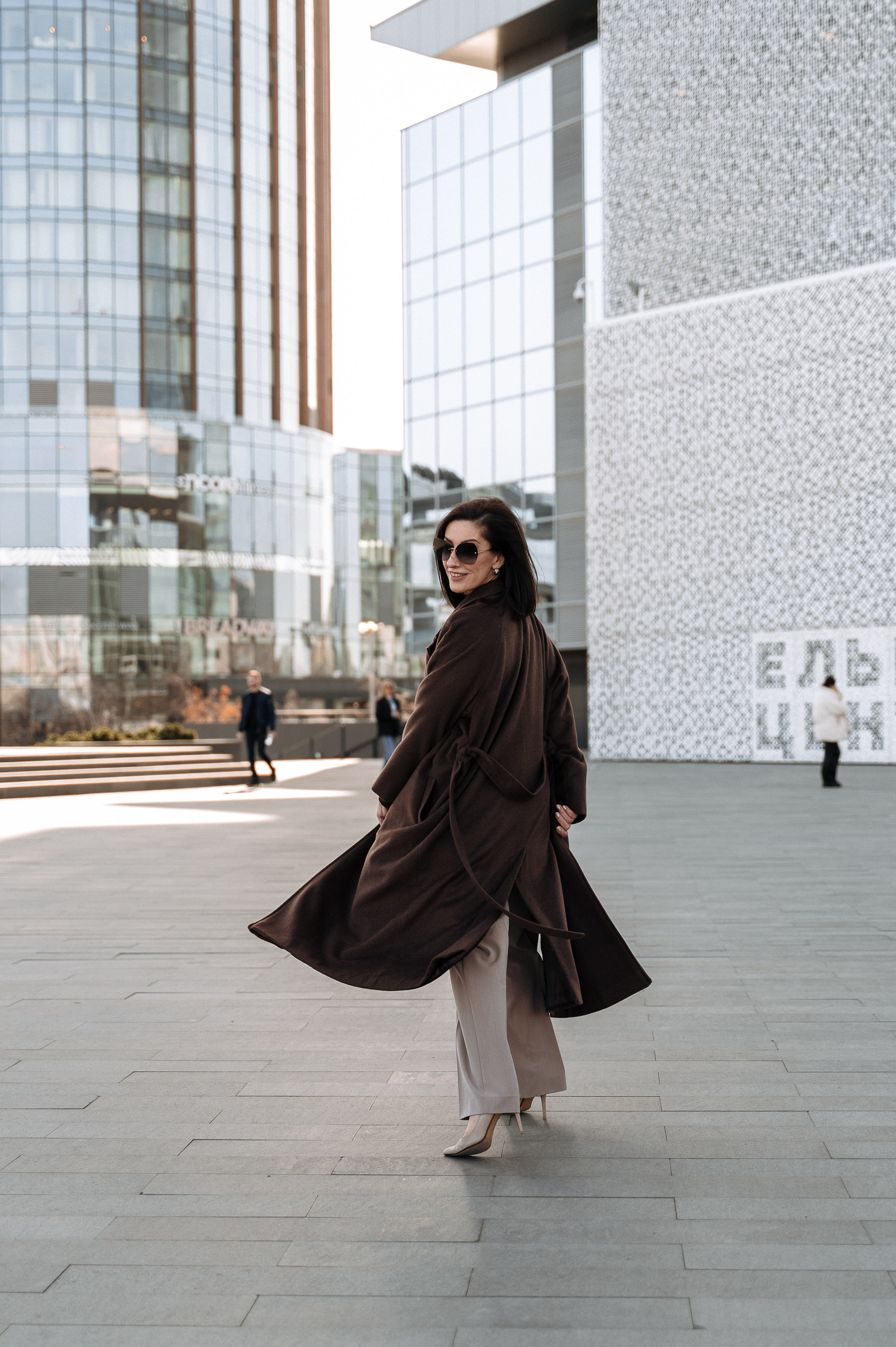 Городская прогулочная фотосессия - стильная женщина в пальто и очках