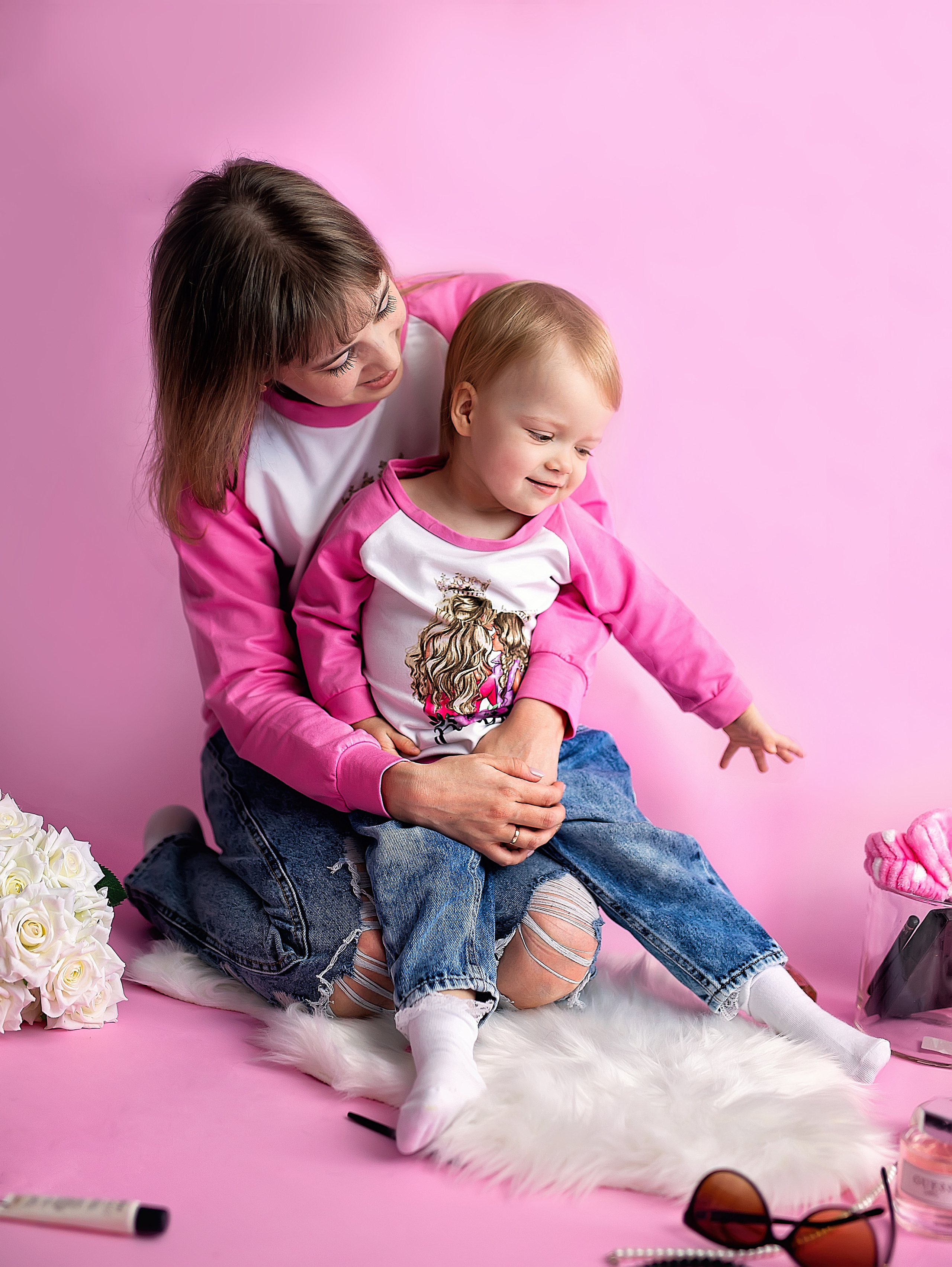 Маленькая девочка со своей мамой одеты в одинаковую одежду.