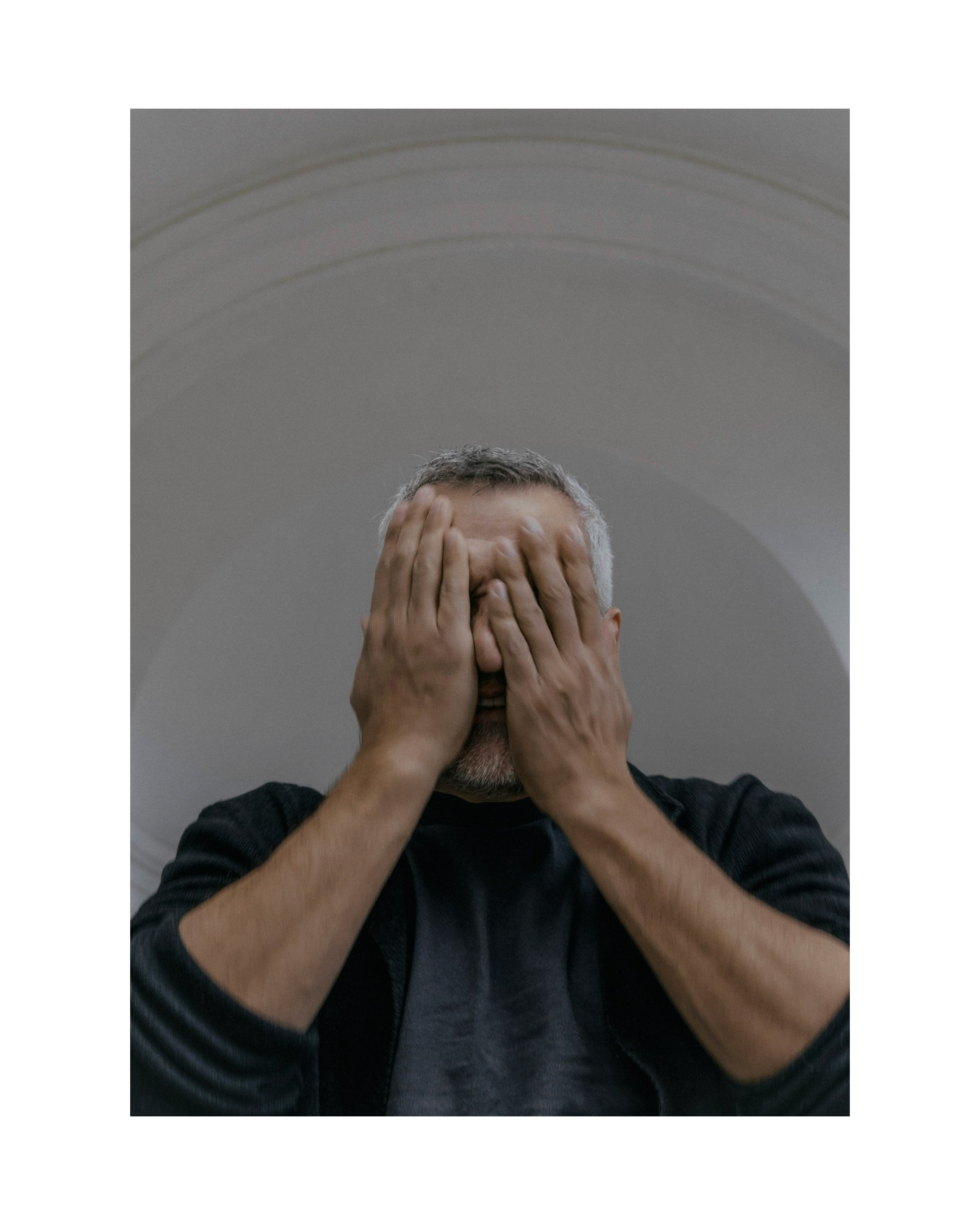 мужчина закрывает лицо руками