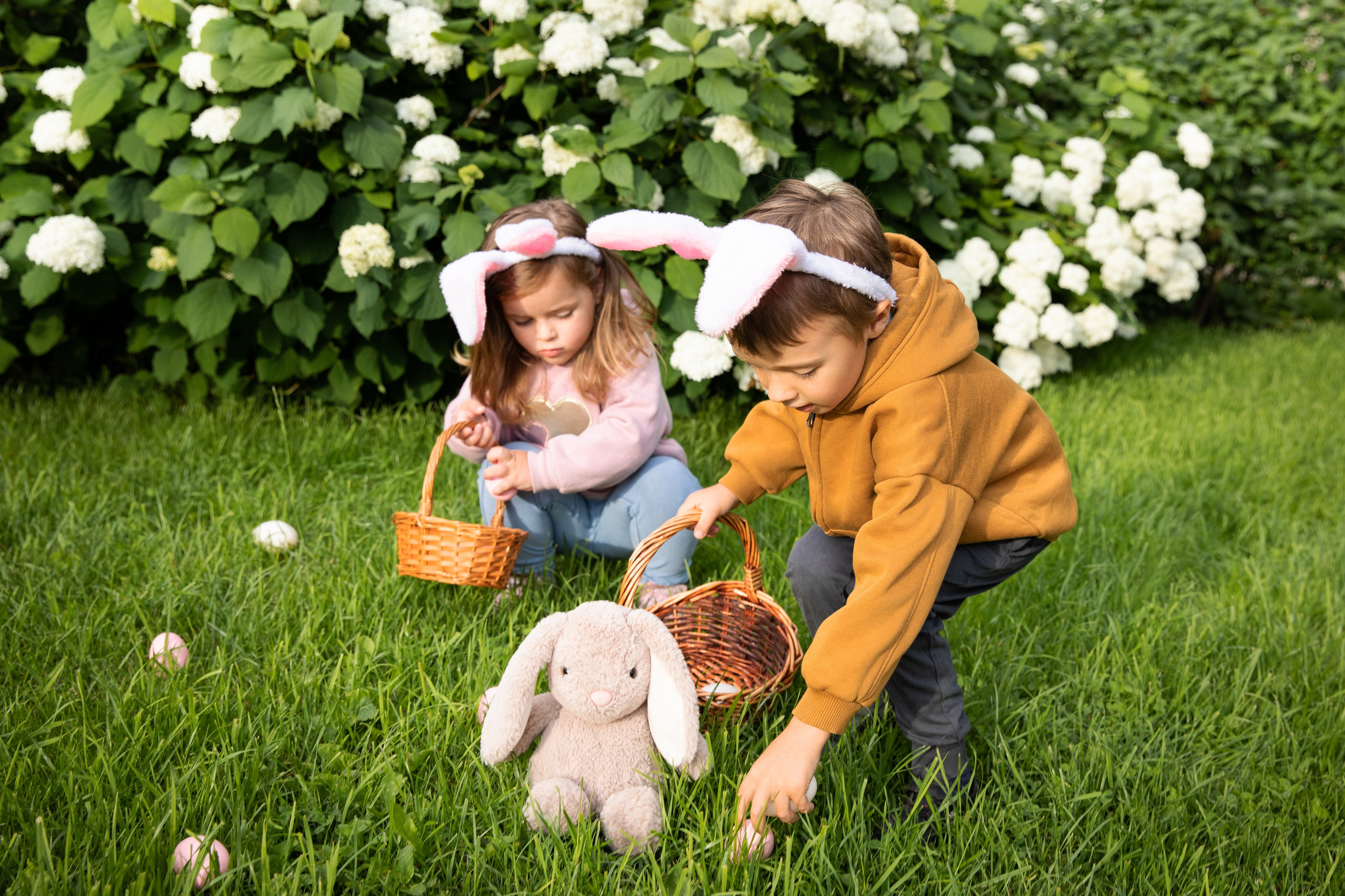 Children with bunny ears and coloured eggs