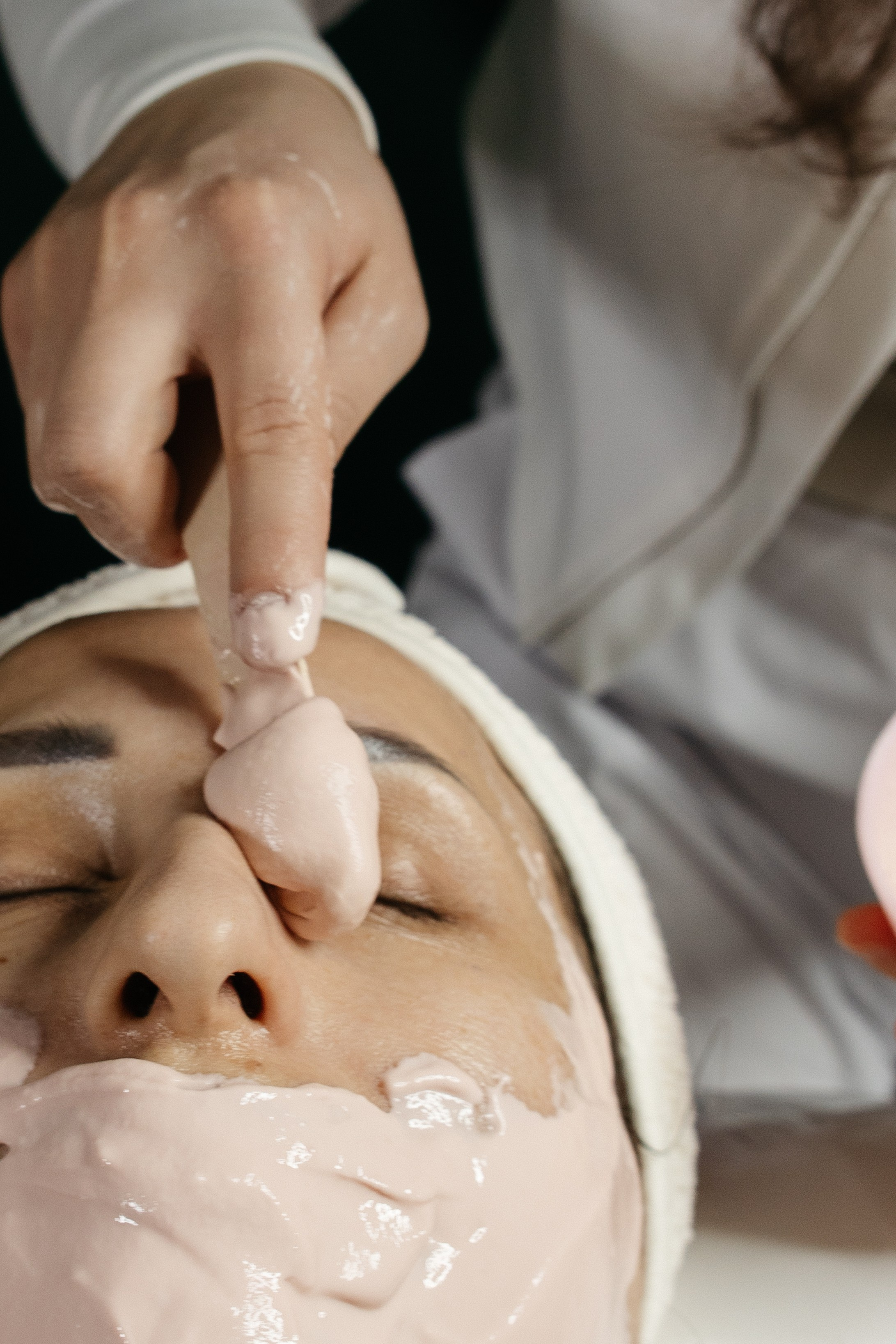 Косметолог наносит маску на лицо модели, деликатные движения - Курск