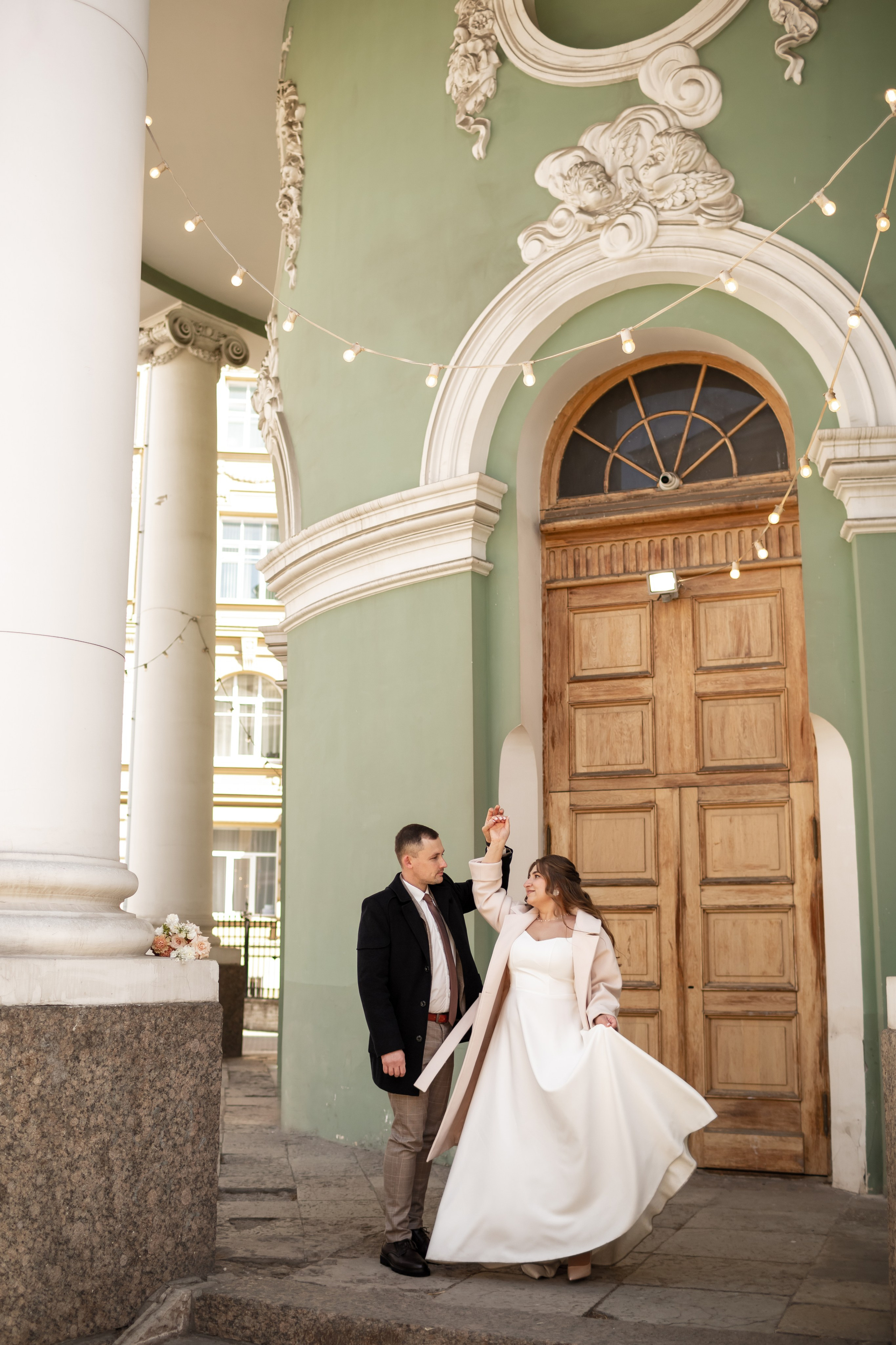 Жених и невеста танцуют на крыльце Анненкирхе.
