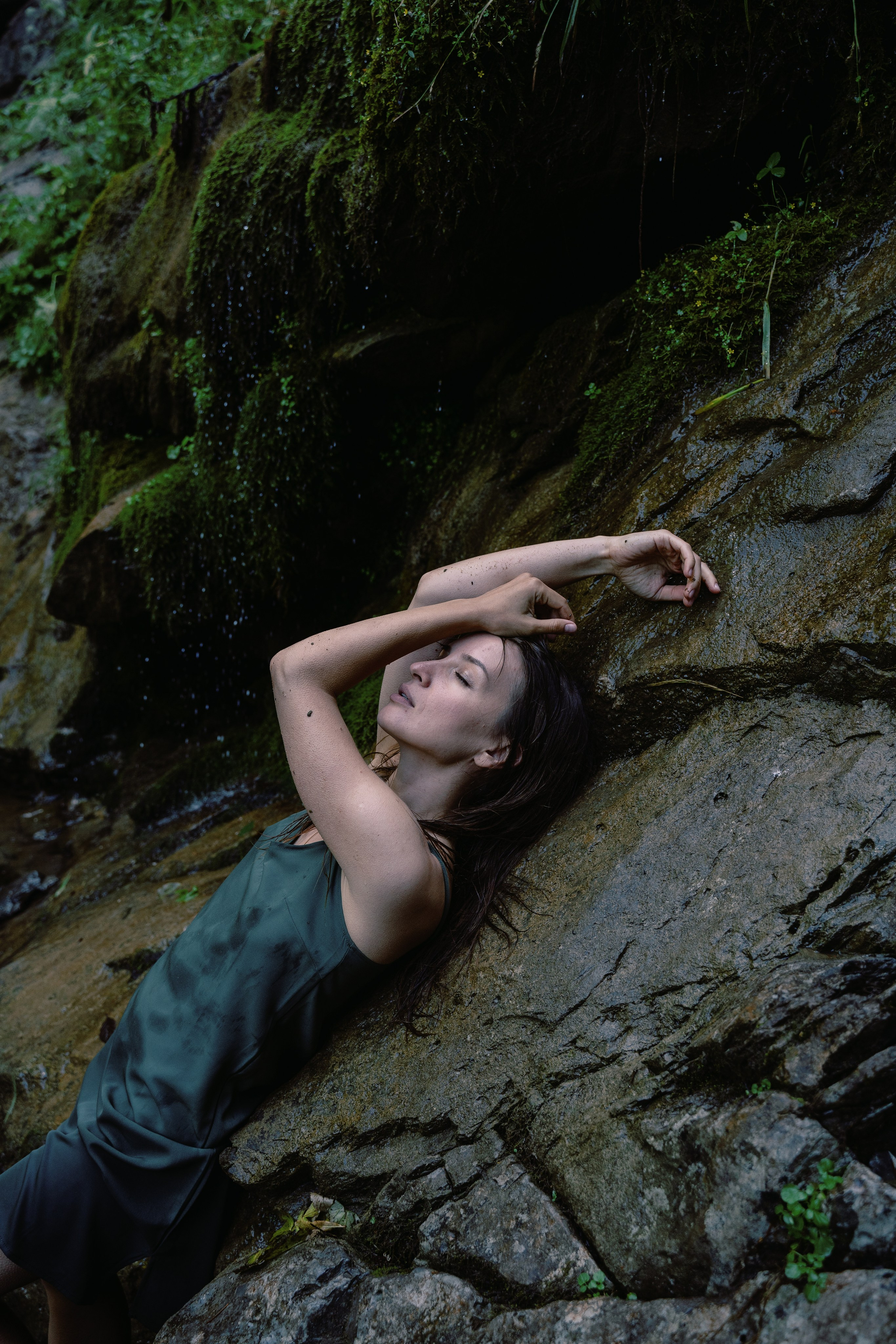 Снимок девушки на фоне водопада с камнями 