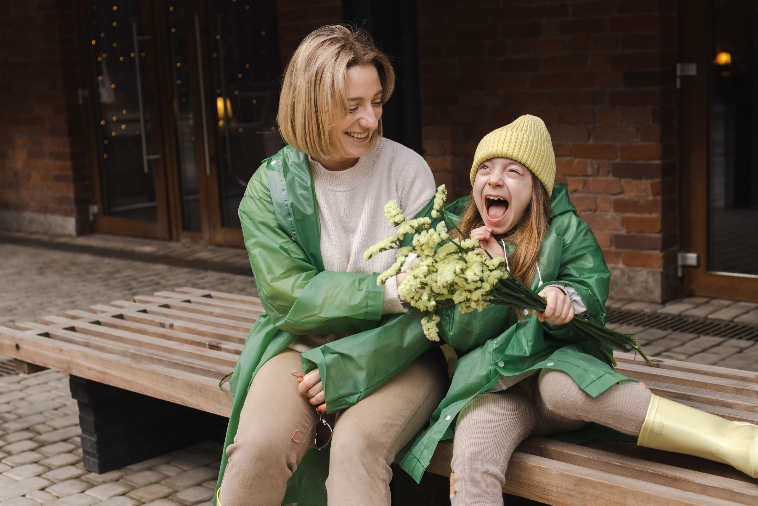 мама с дочкой в дождевиках играют и гуляют