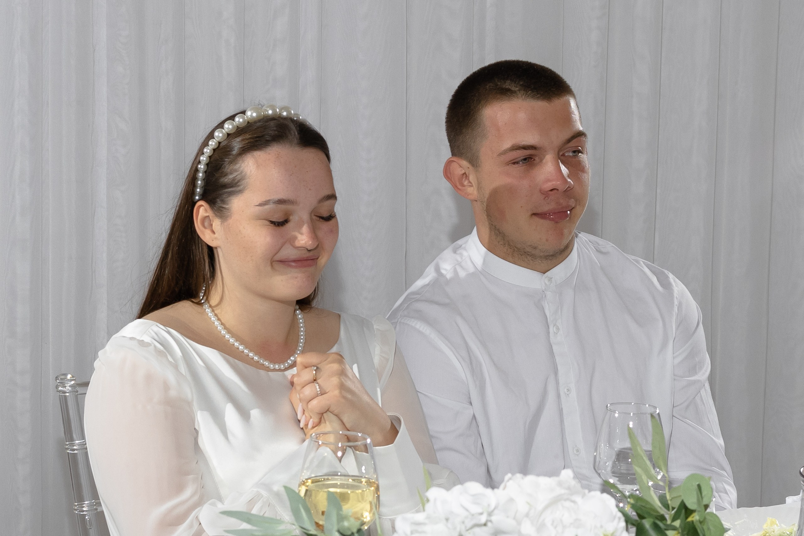 Жених с невестой сидят за праздничным столом