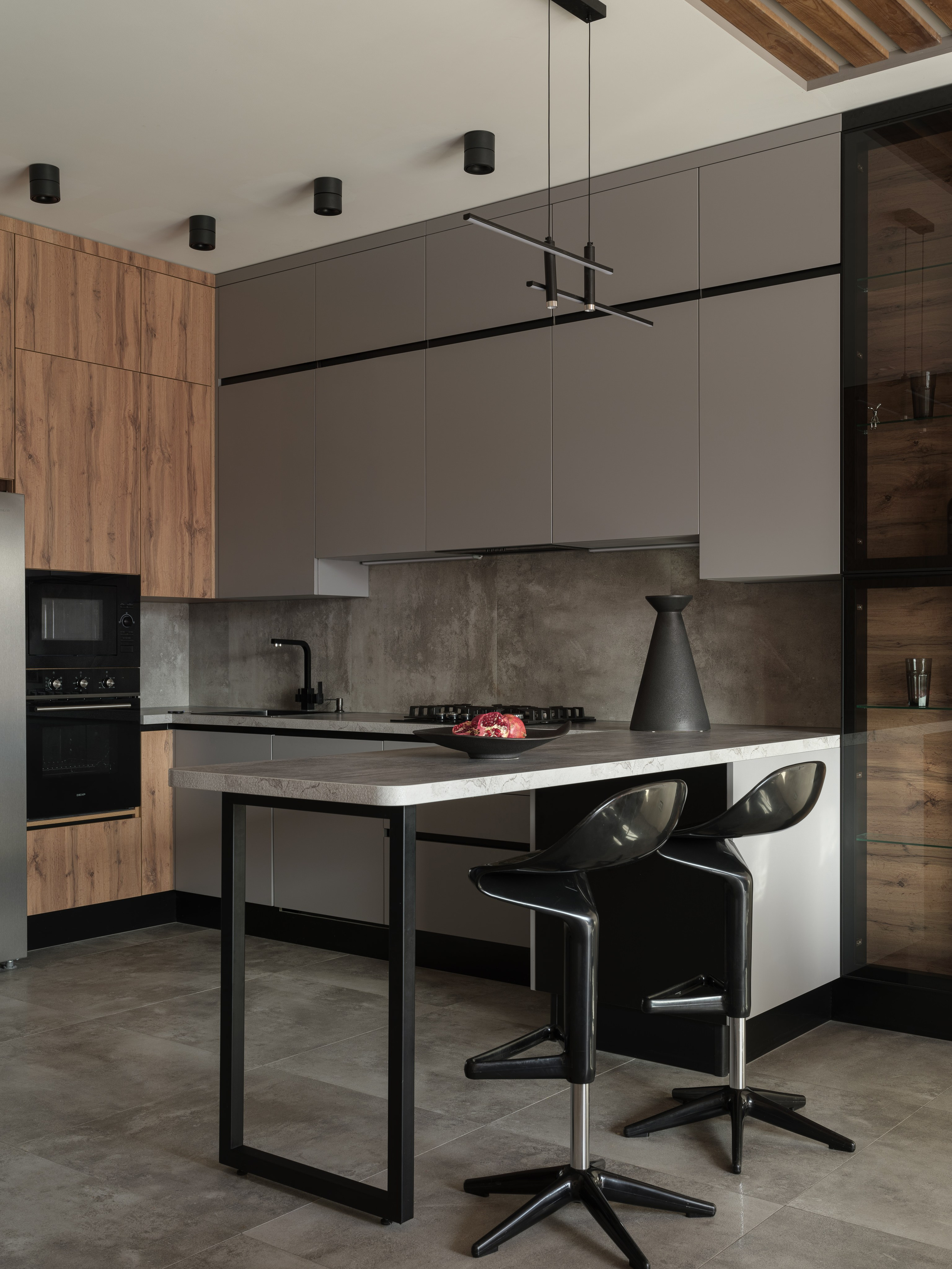 Современная кухня в стиле минимализм с островом, серыми фасадами и чёрными акцентами. Комбинация бетона и дерева, подчеркнутая светом. Автор дизайна Алина Дёрова, стилист Наталья Якушева, фотограф Сергей Денисенко.