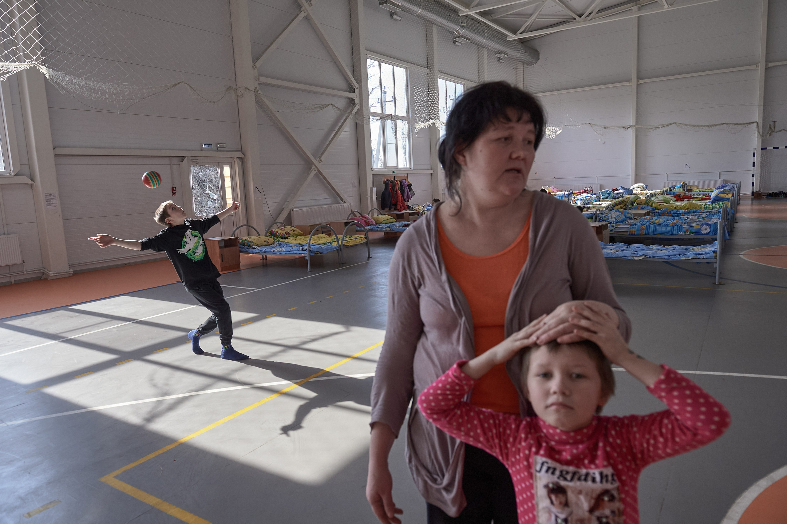 A mother of multiple children, Liliya Valiullina, along with her children from the city of Uglegorsk in the Donetsk region, evacuated to the Rostov region following intensified shelling, is seen in a temporary accommodation center for refugees set up in the sports hall of a rural cultural center in Lenin Hamlet, Rostov region, on February 22, 2022.