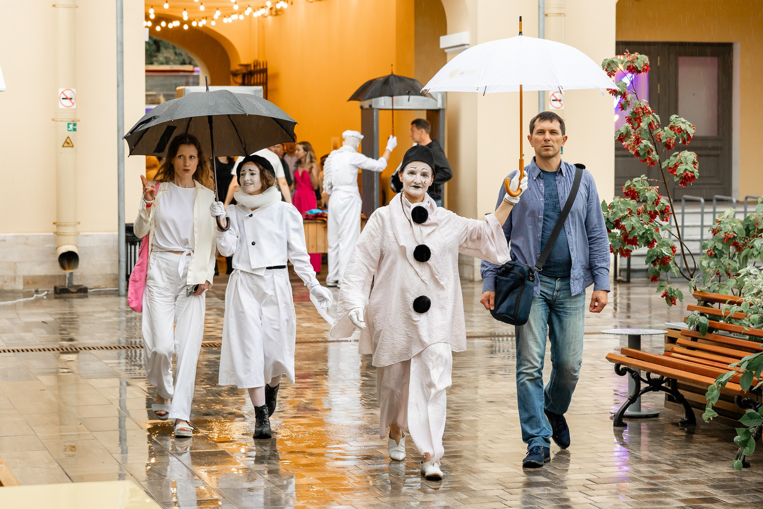 Встреча гостей концерта под зонтиками во время дождя