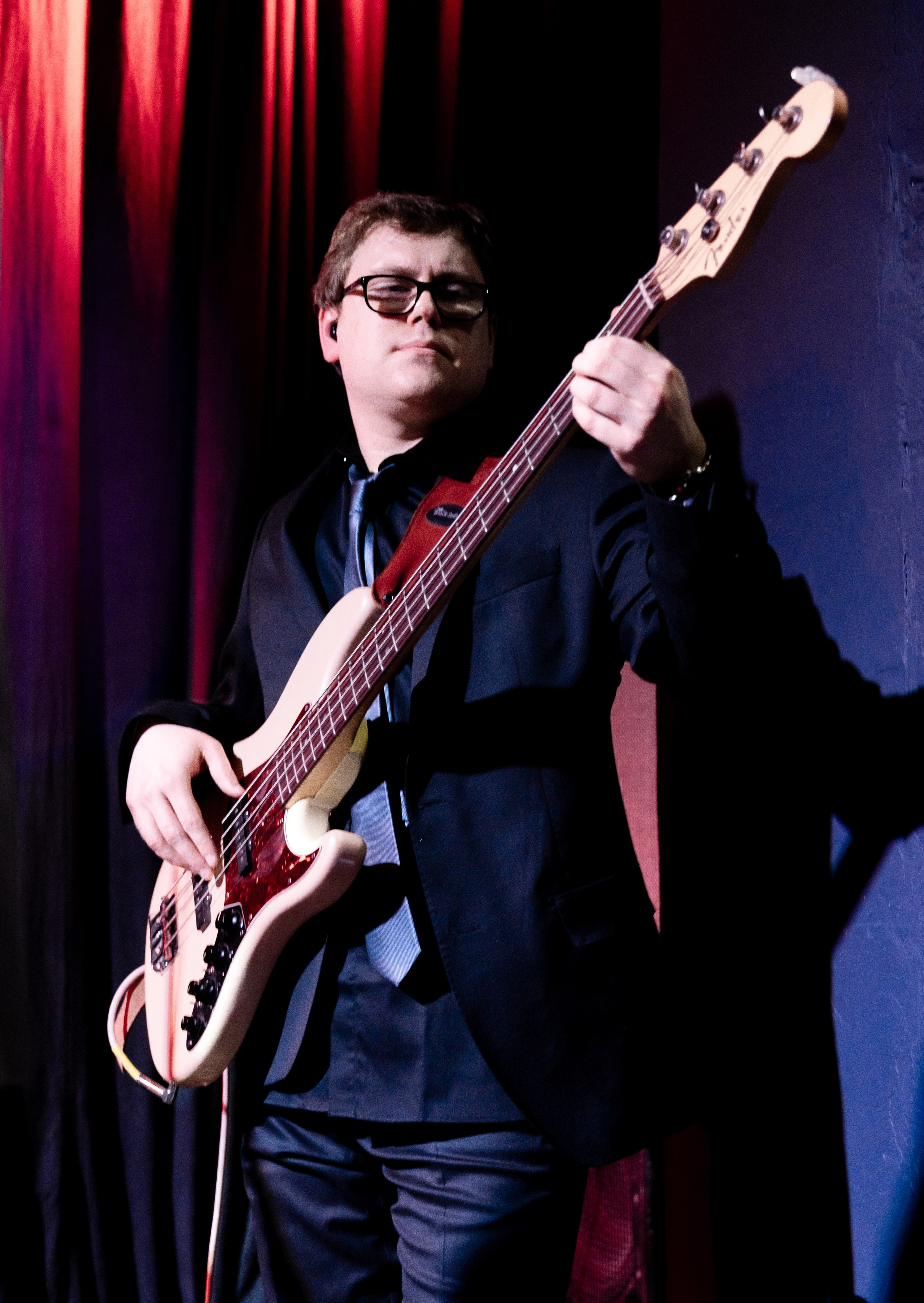 Бар Мачты. Радио Сатурн. Живое фото бас-гитариста на концерте в клубе Санкт-Петербурга — музыкант в тёмном костюме, репортажная концертная съёмка Евгения Мальцева.