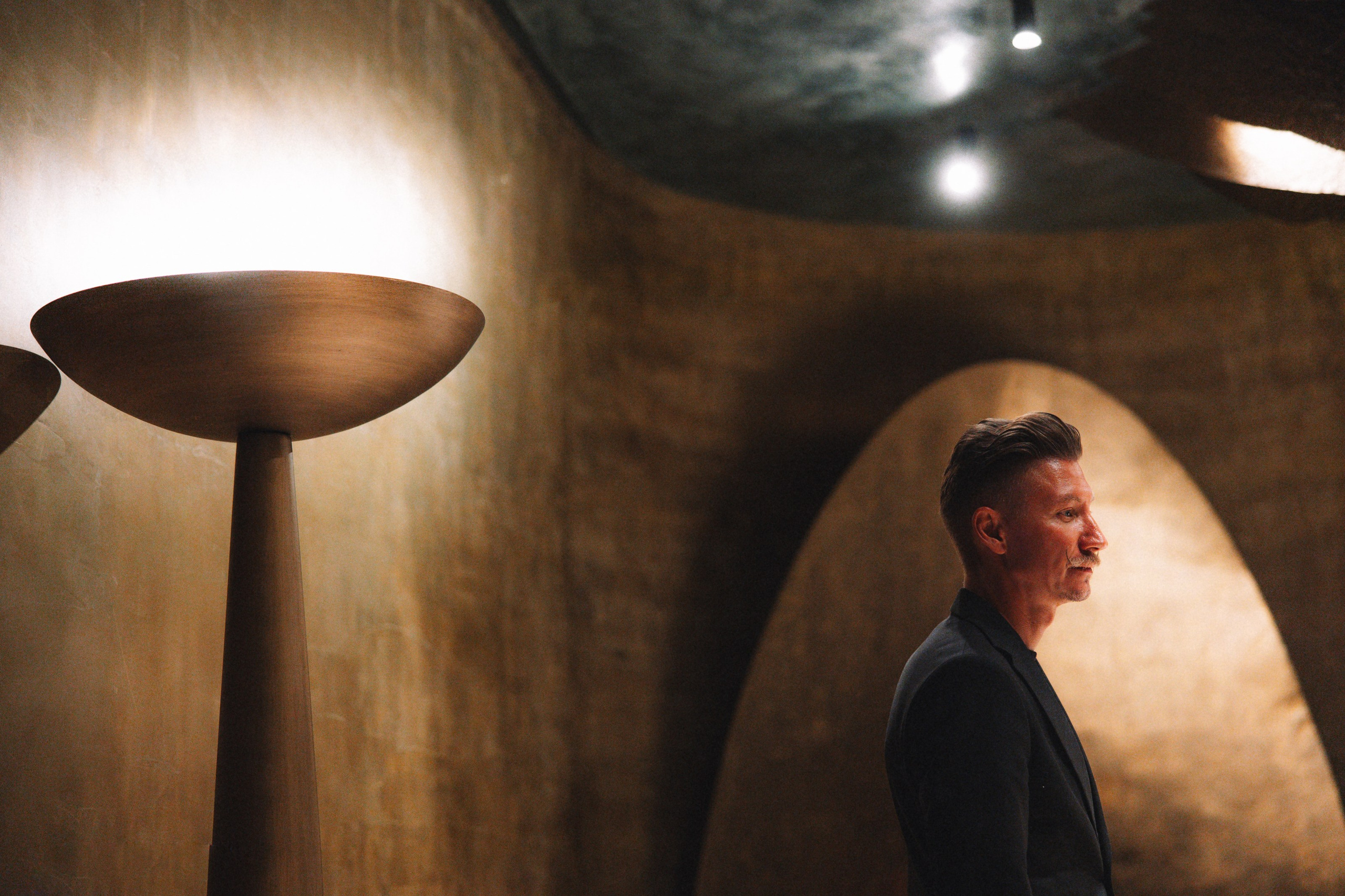 Портрет в интерьере: сомелье в темном костюме в футуристичном интерьере отеля с мягким теплым светом. Ресторан Le Ri  Mantera SUPREME