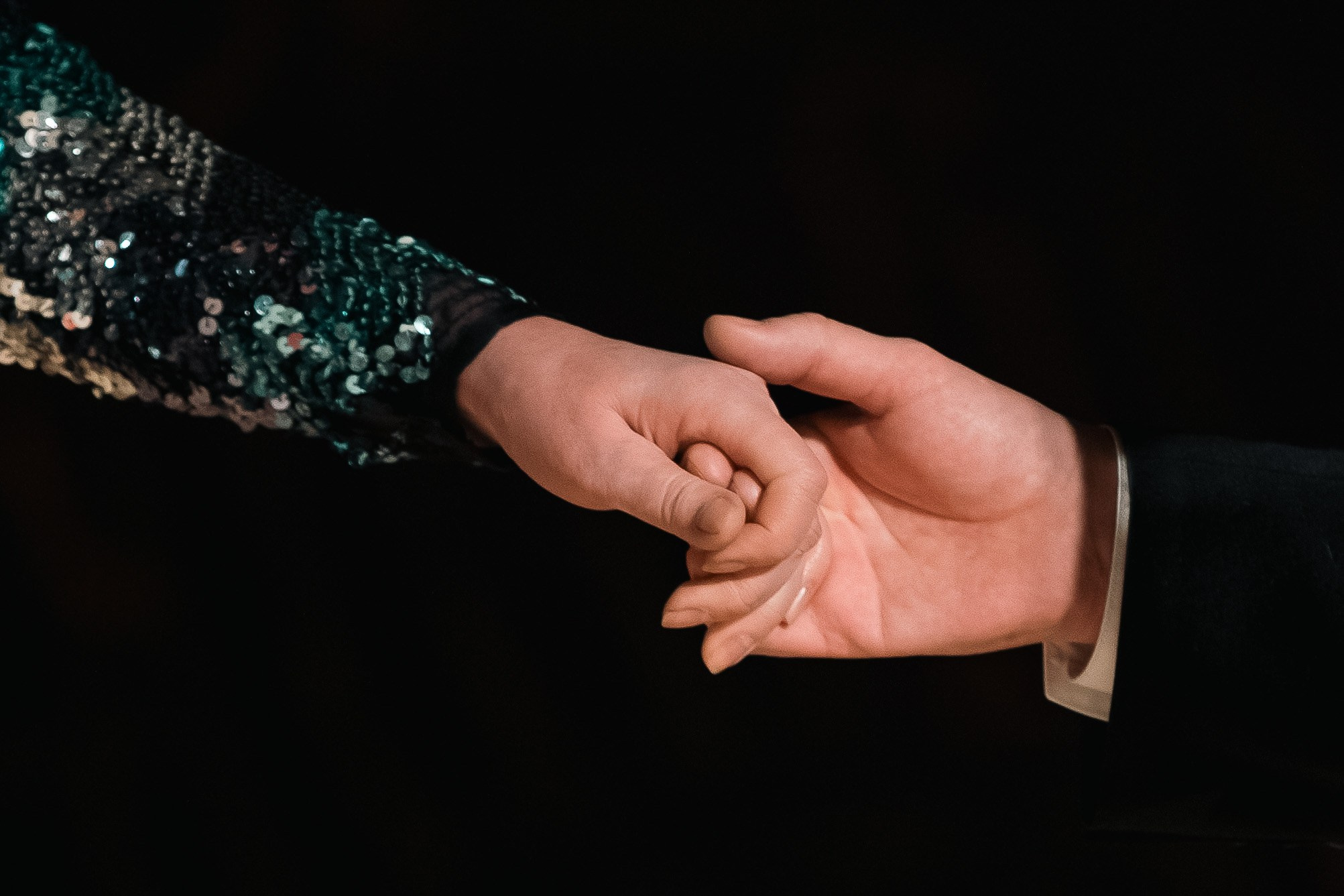 Одна рука держит другую руку. Кадр из репортажной съемки мероприятия.