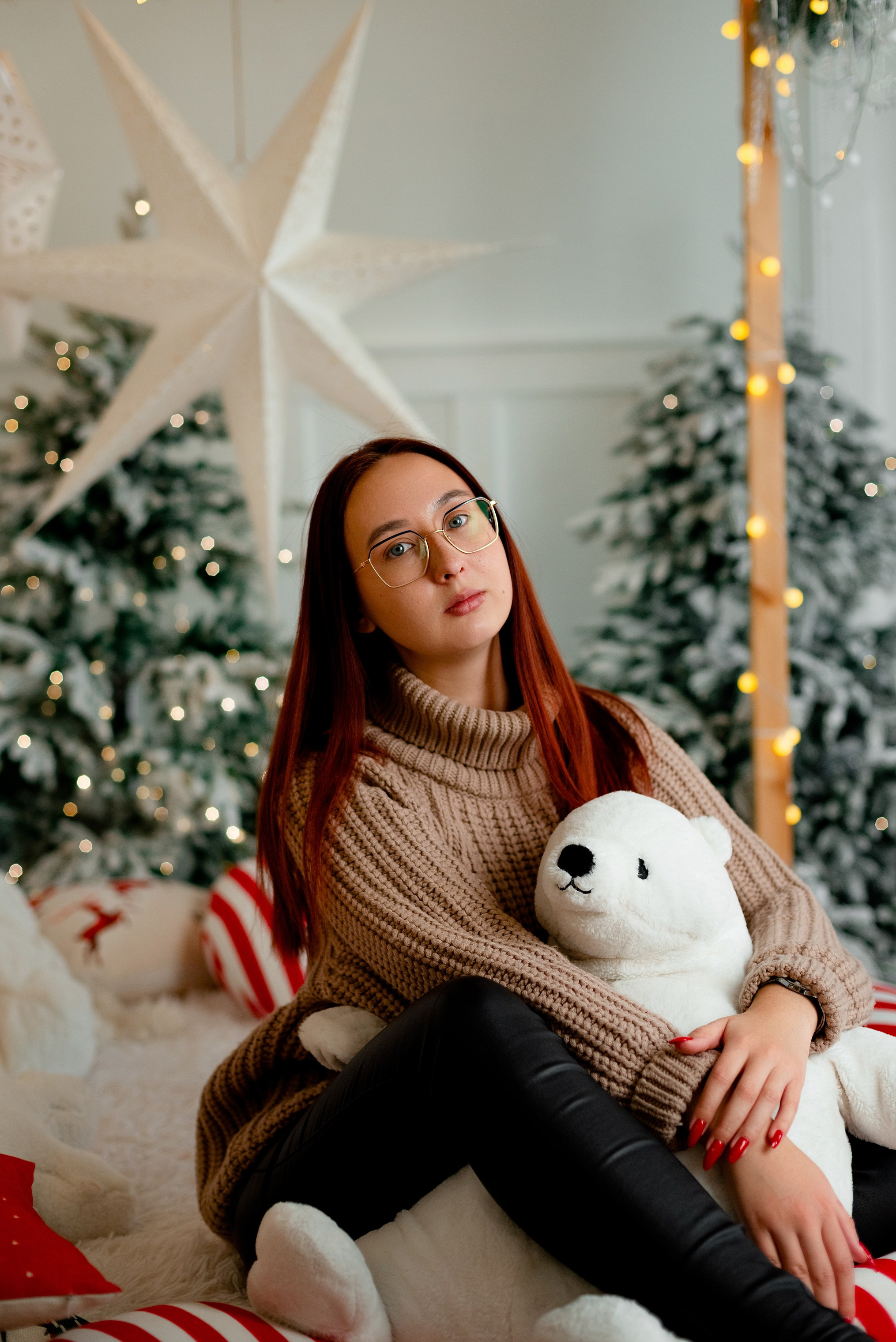 Девушка с игрушечным медведем у новогодней елки