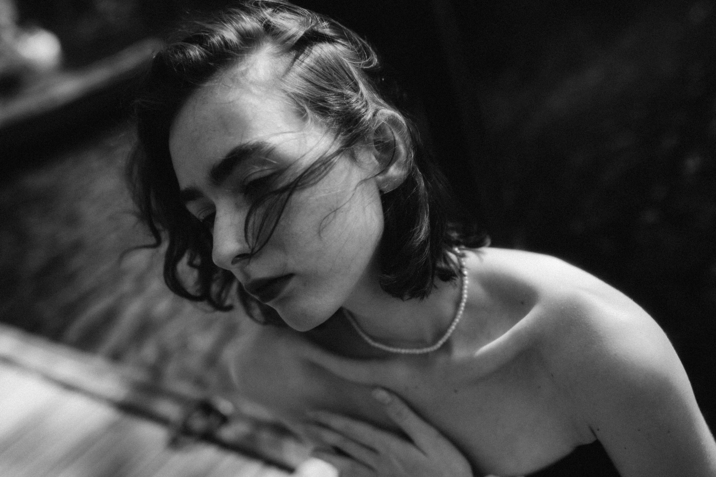 Девушка с голыми плечами прижимает руку к груди