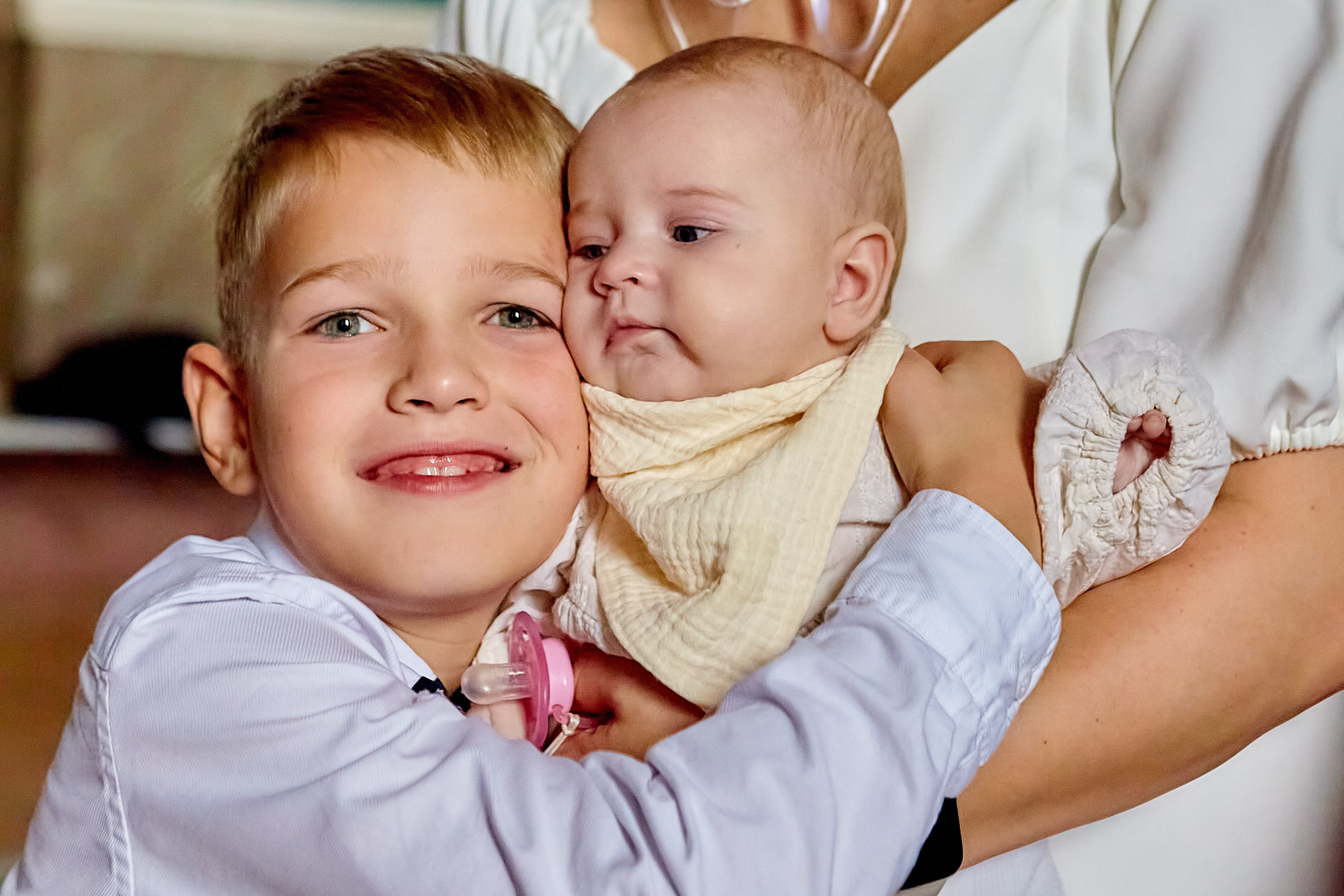 Маленький братик с сестренкой в обнимку на Крещении