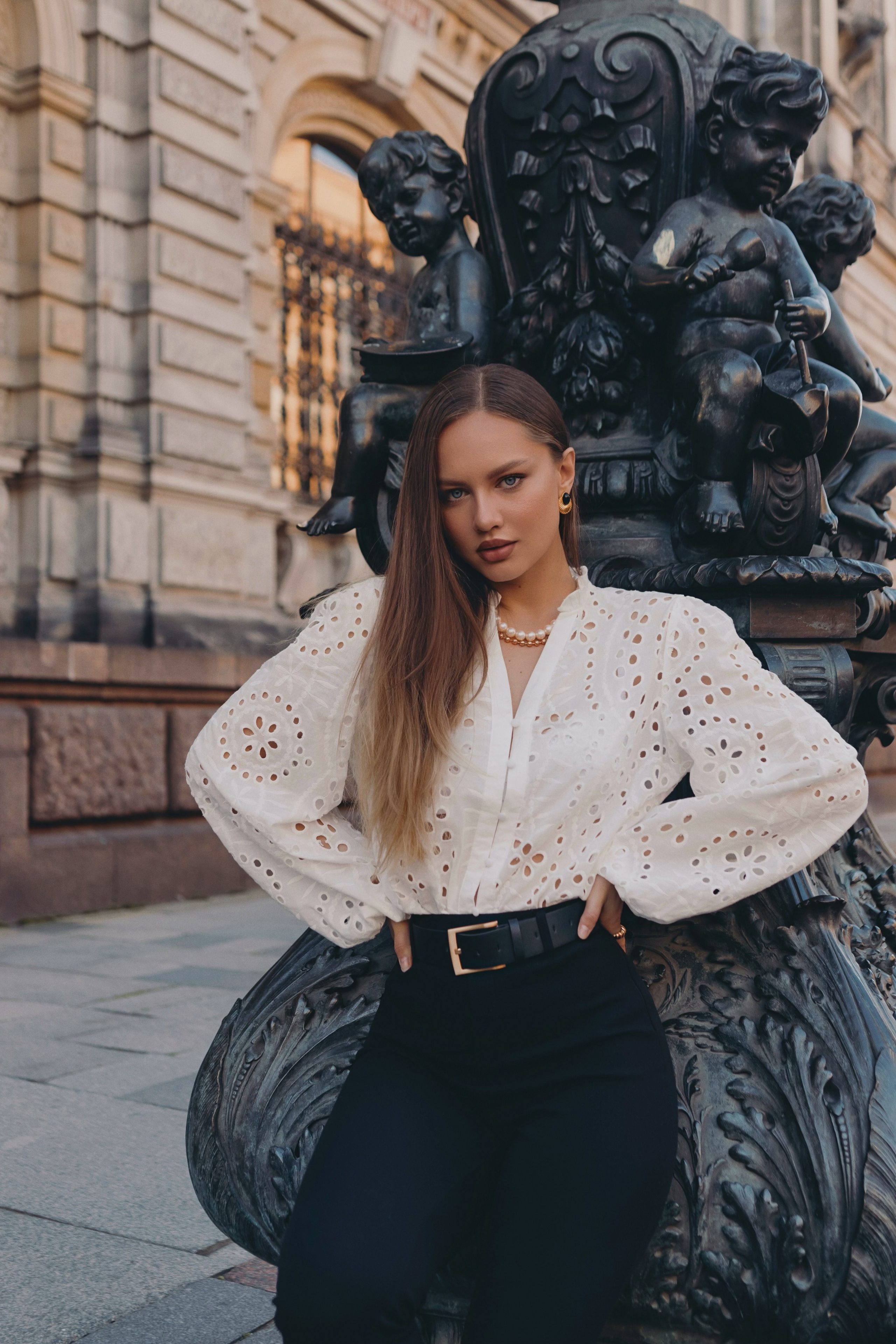 Девушка модель в черных джинсах и белой блузке