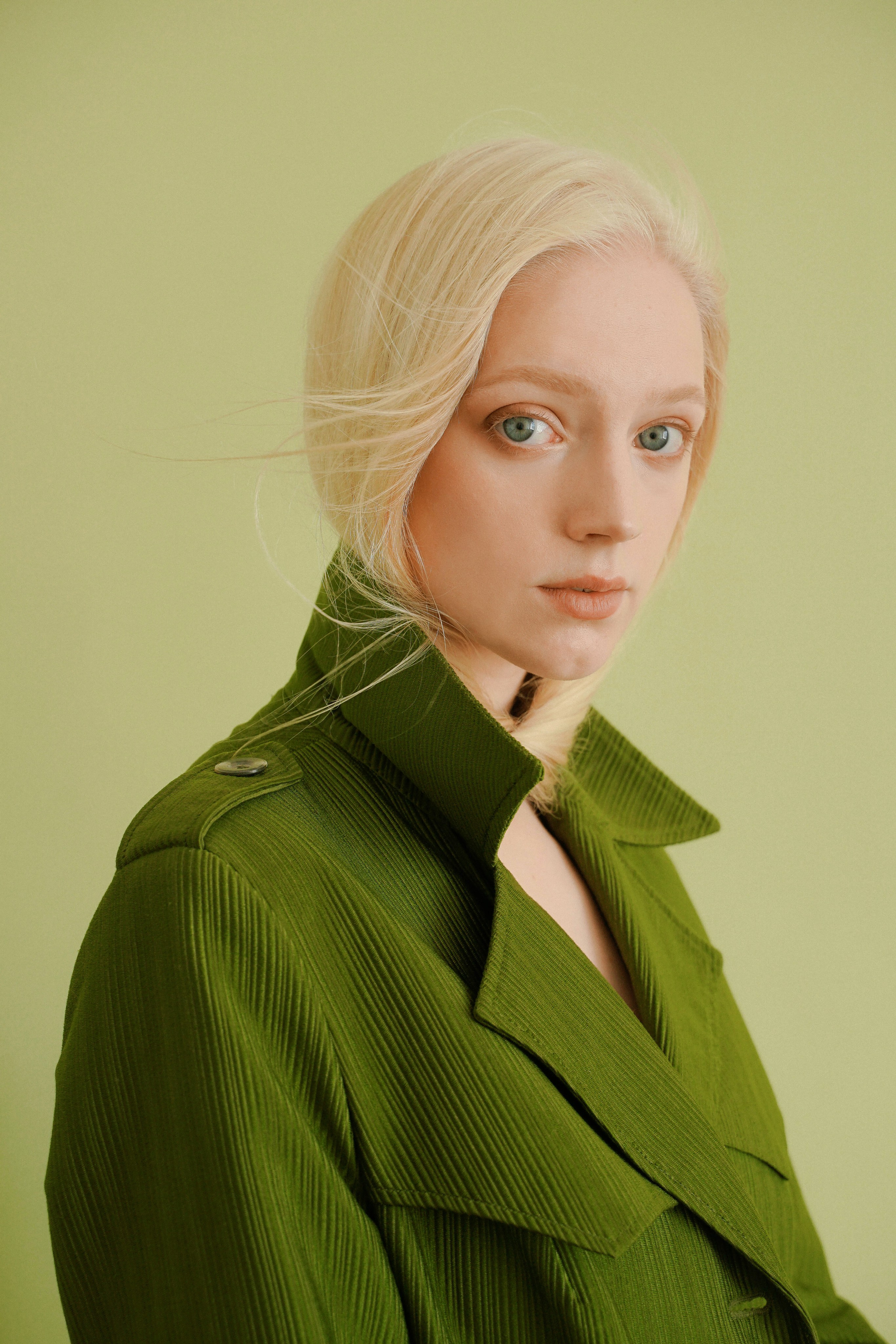 Девушка модель блондинка в зеленом пальто