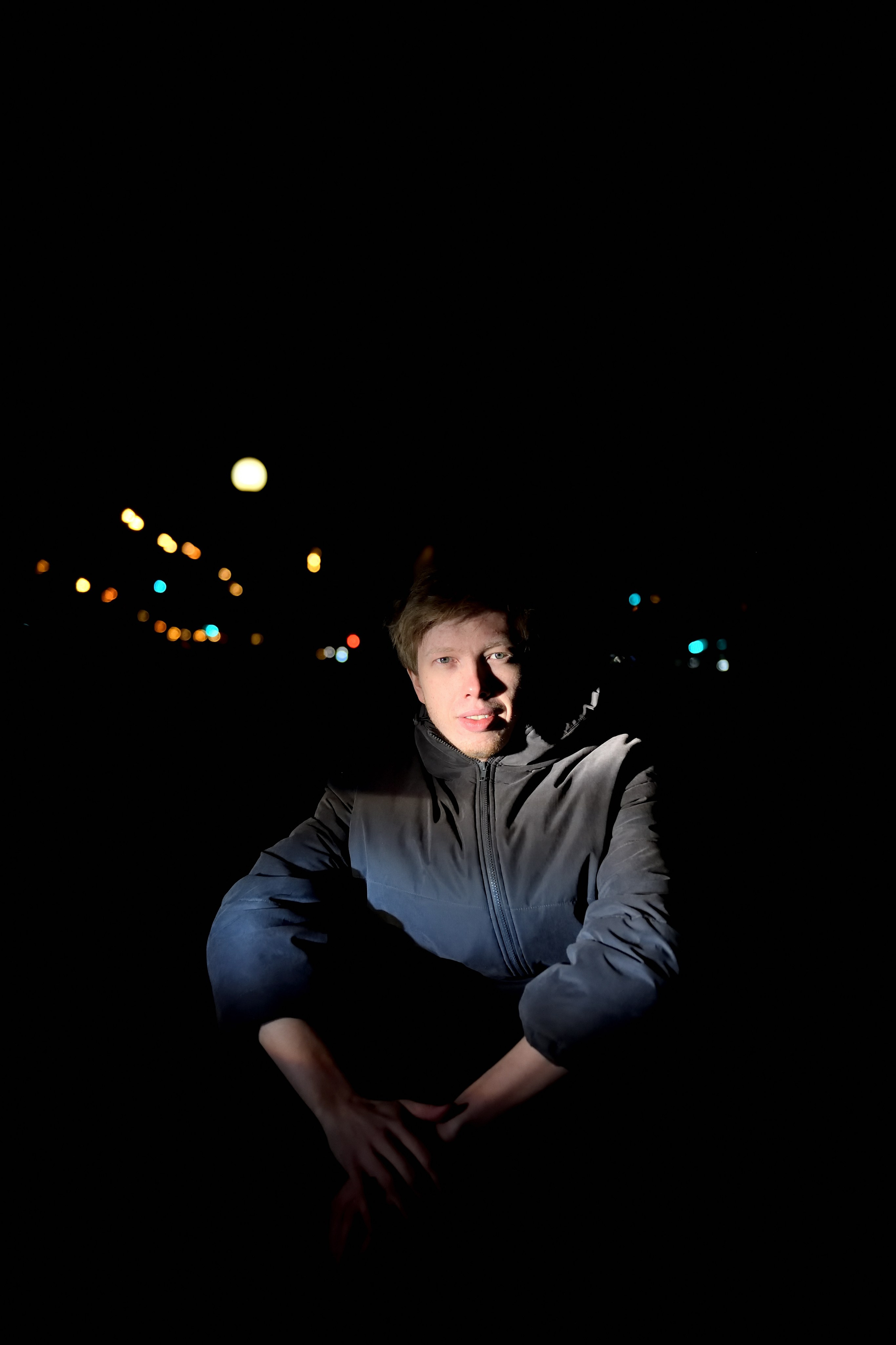 Портрет молодого мужчины в свете фар автомобиля.