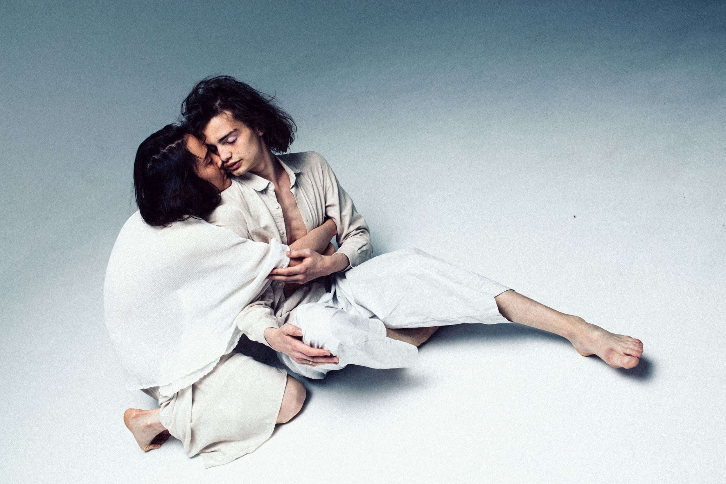 девушка в светлой одежде нежно обнимает парня