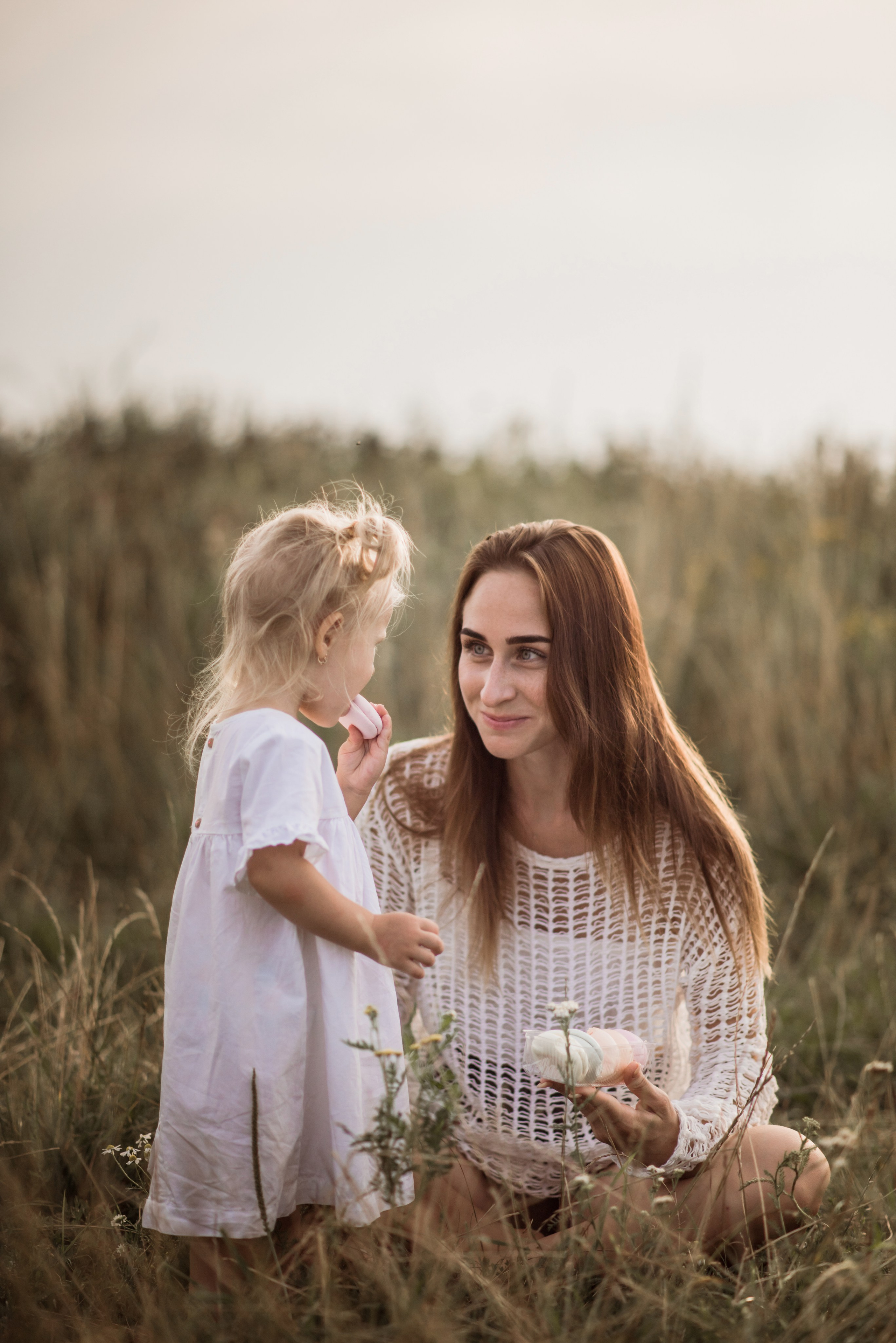 Mom sitting with her children in a meadow
