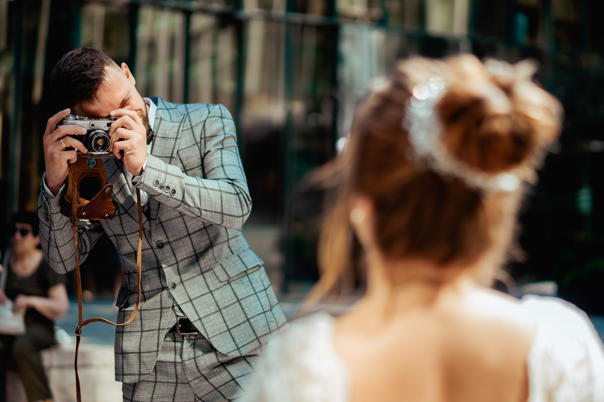 жених фотографирует невесту в зеркальном дворике 