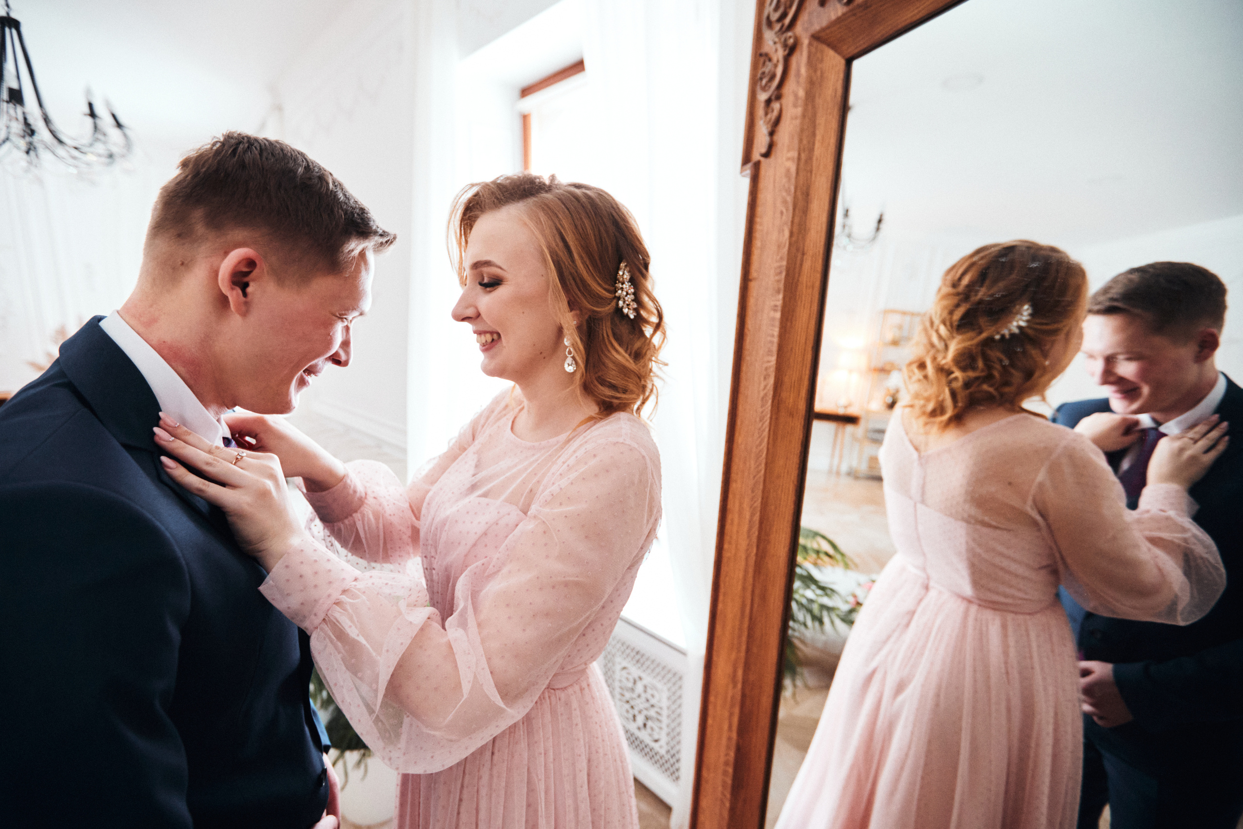 Невеста поправляет костюм жениха на свадьбе