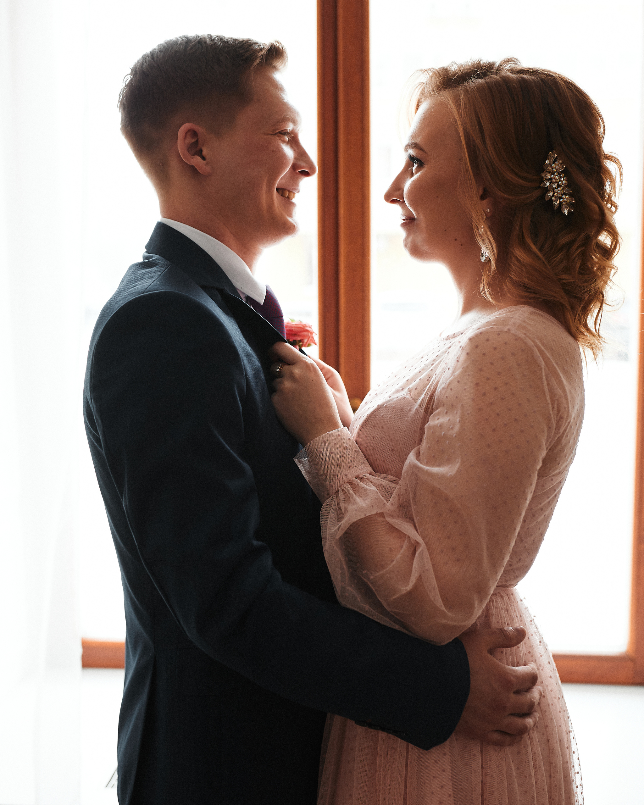 Свадебная фотография жениха и невесты у окна