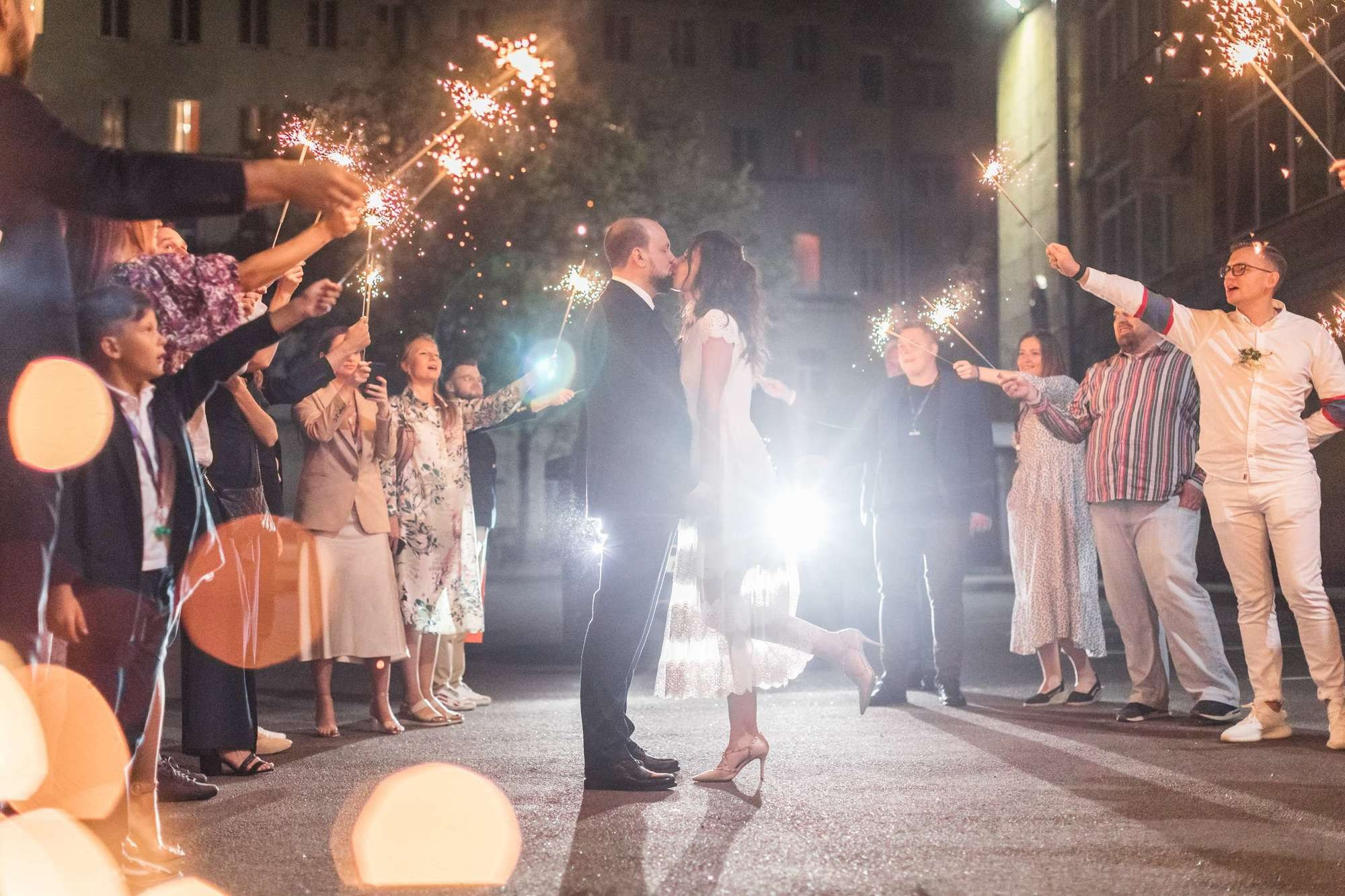 Жених и невеста целуются вокруг бенгальских огней