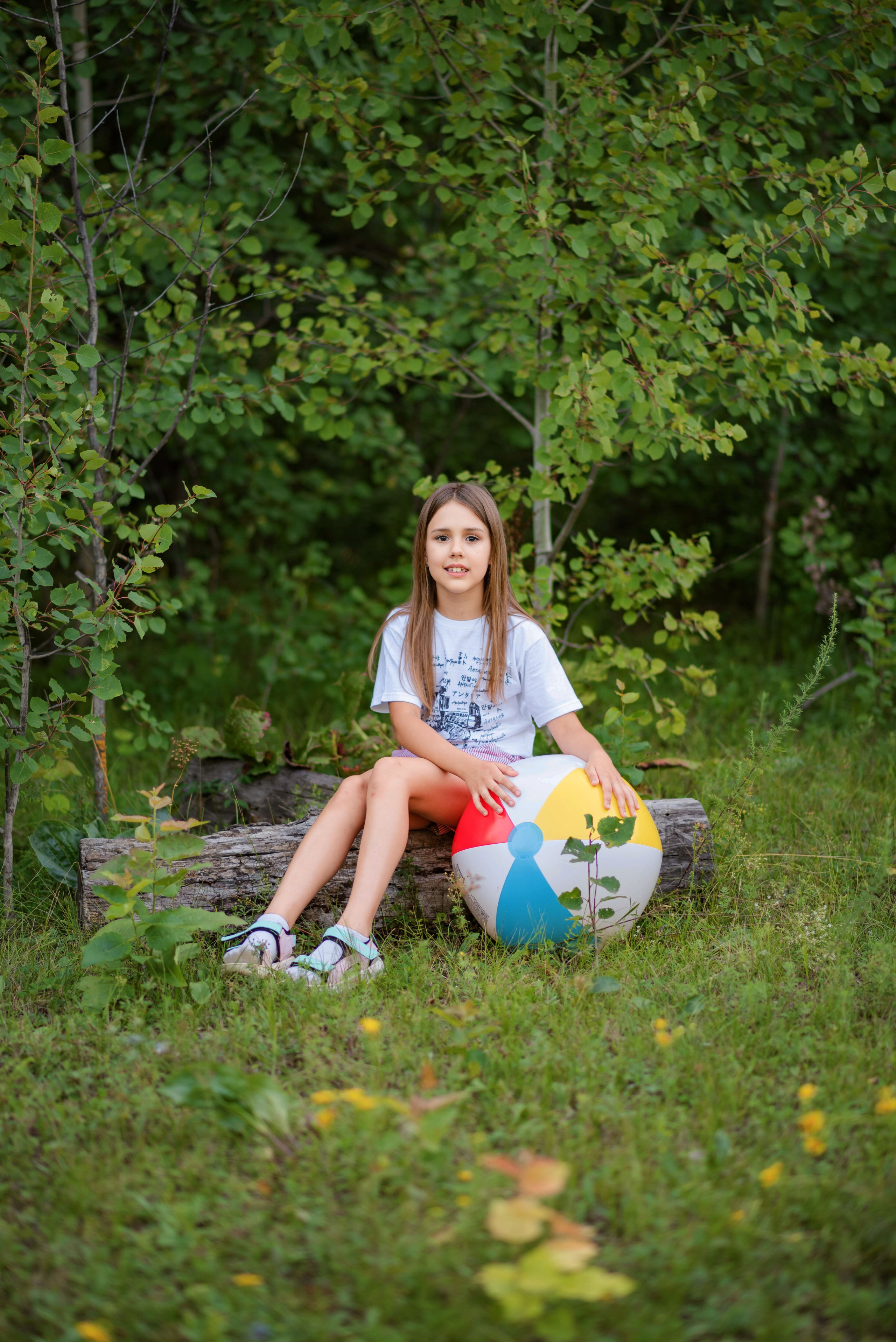 Портрет девочки с мячиком на фоне леса.