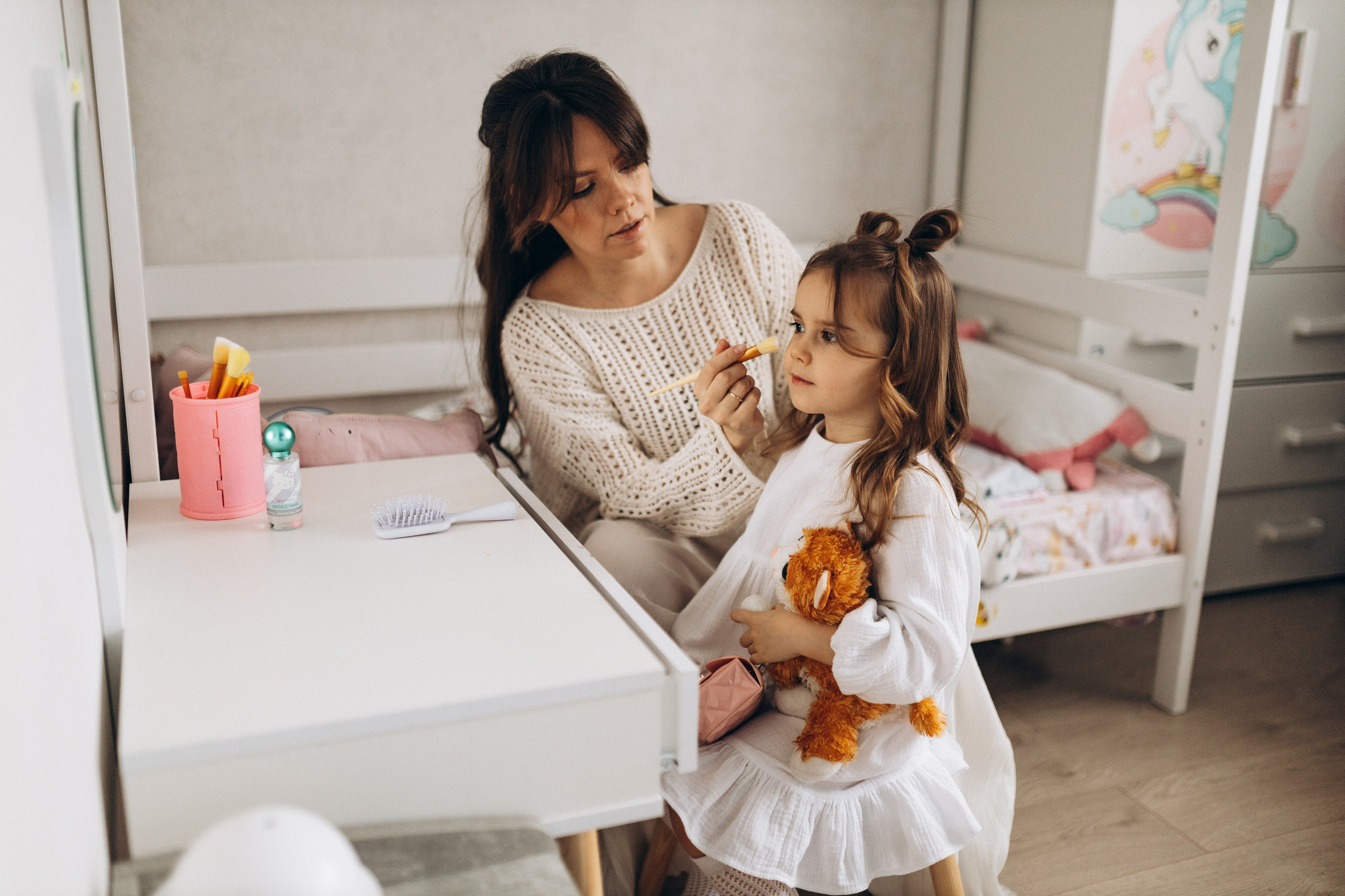 мама помогает маленькой дочке укладывать волосы