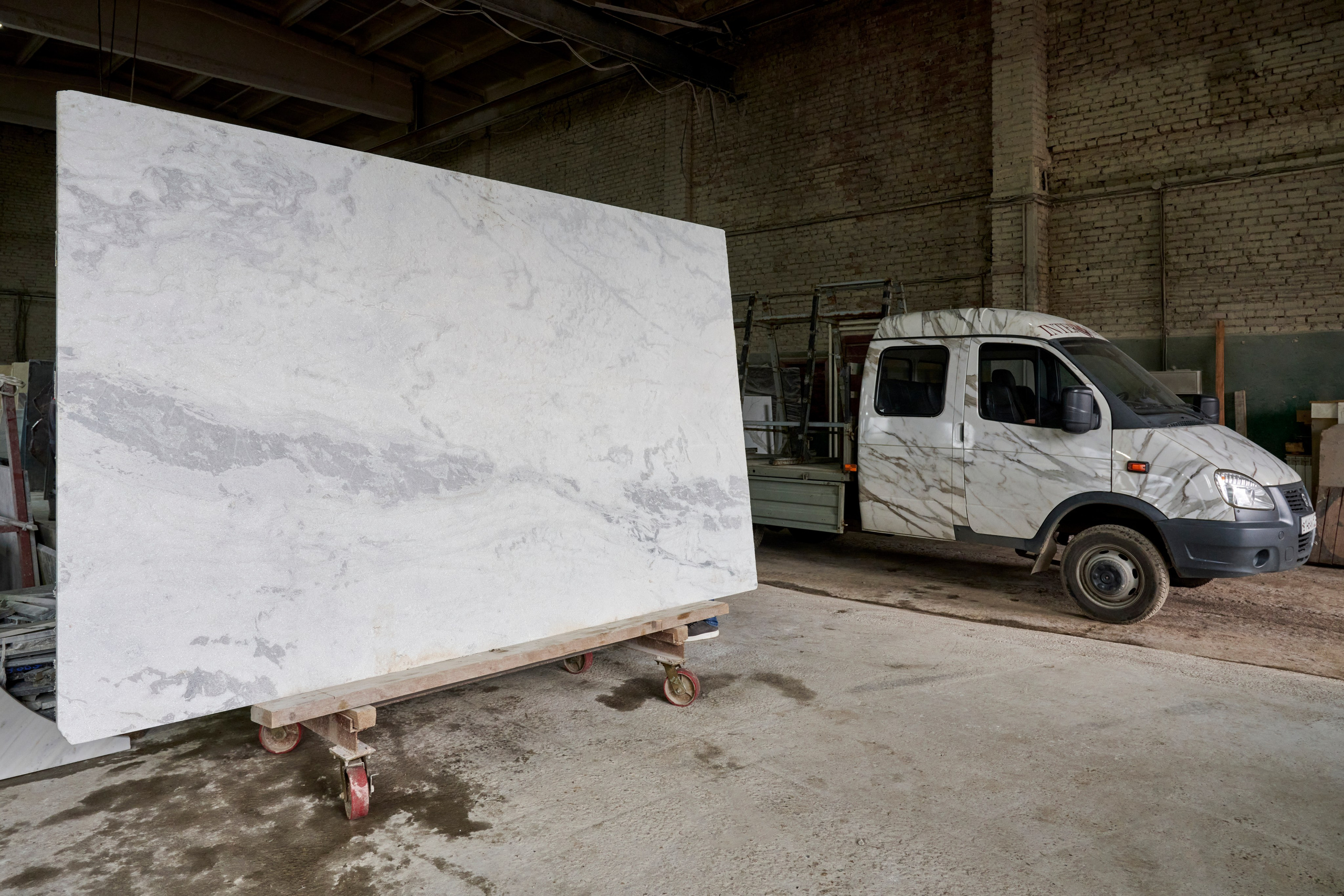 Большая белая плита на стойках, погрузка в помещении