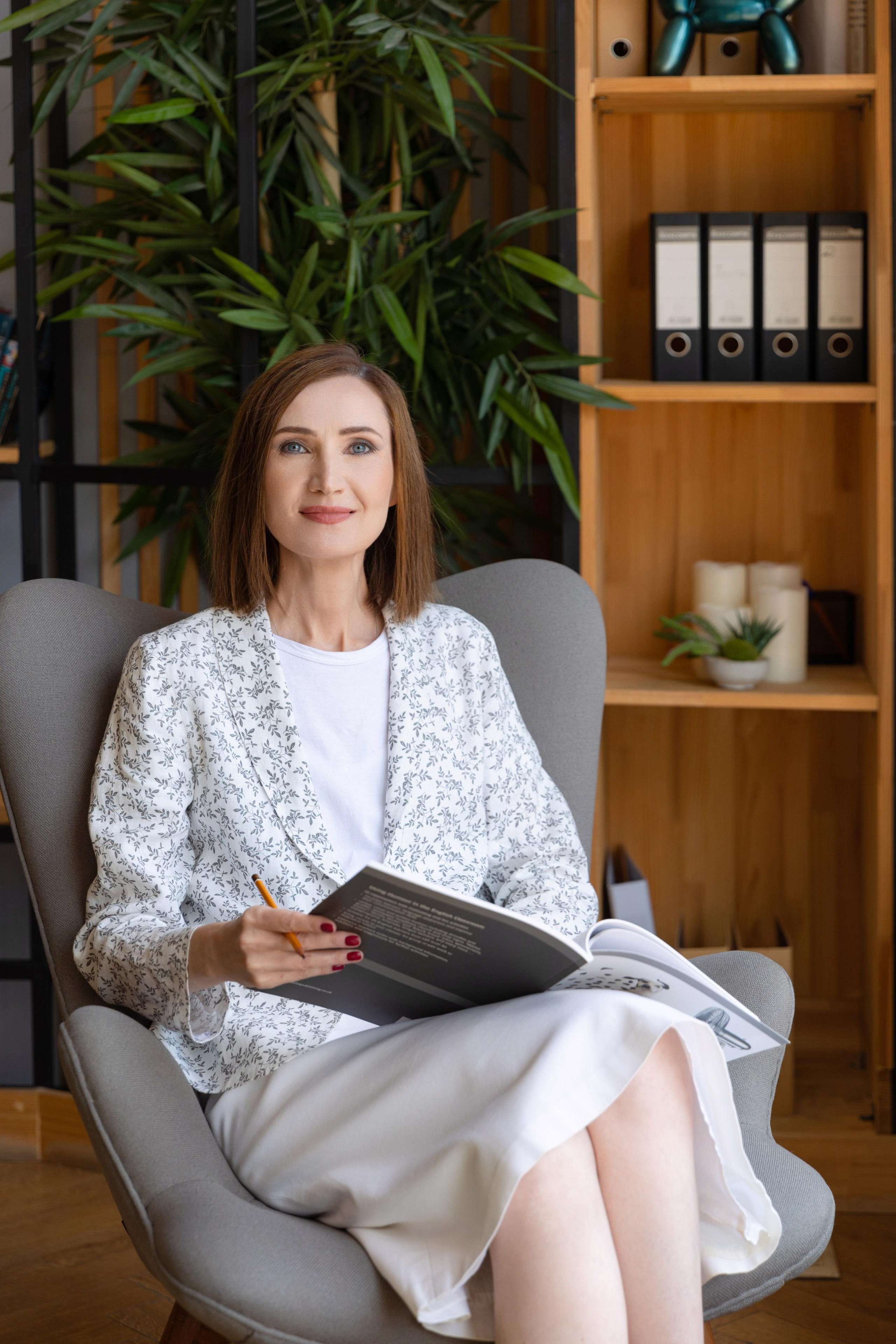 Женщина преподаватель сидит в кресле в офисе