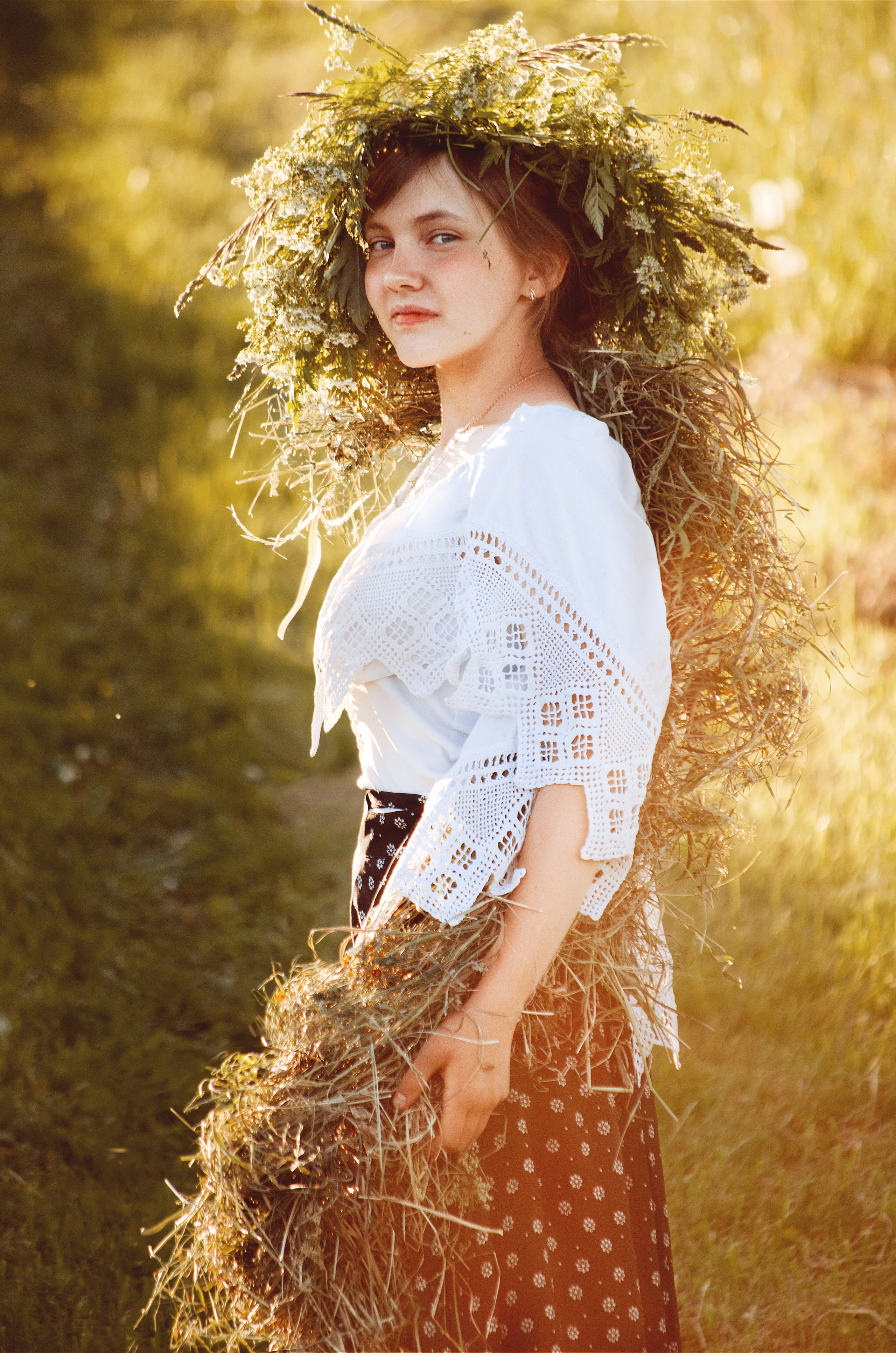 Девушка с венком из травы на голове в поле