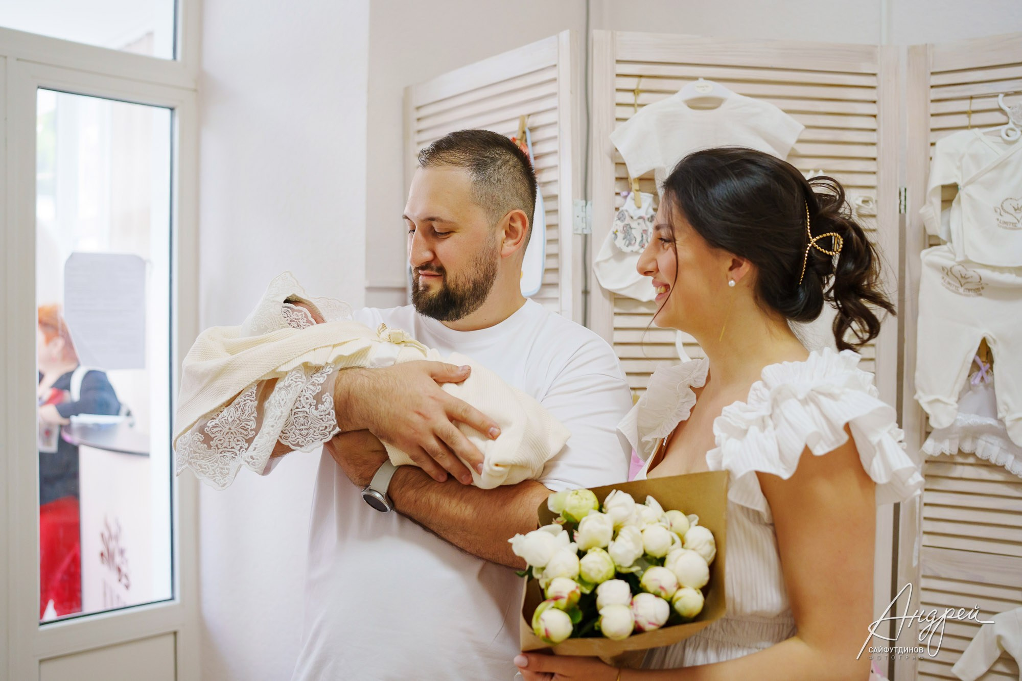 Молодые родители держат и любуются новорожденной дочкой в роддоме Ростова-на-Дону, фотосъемка выписки.