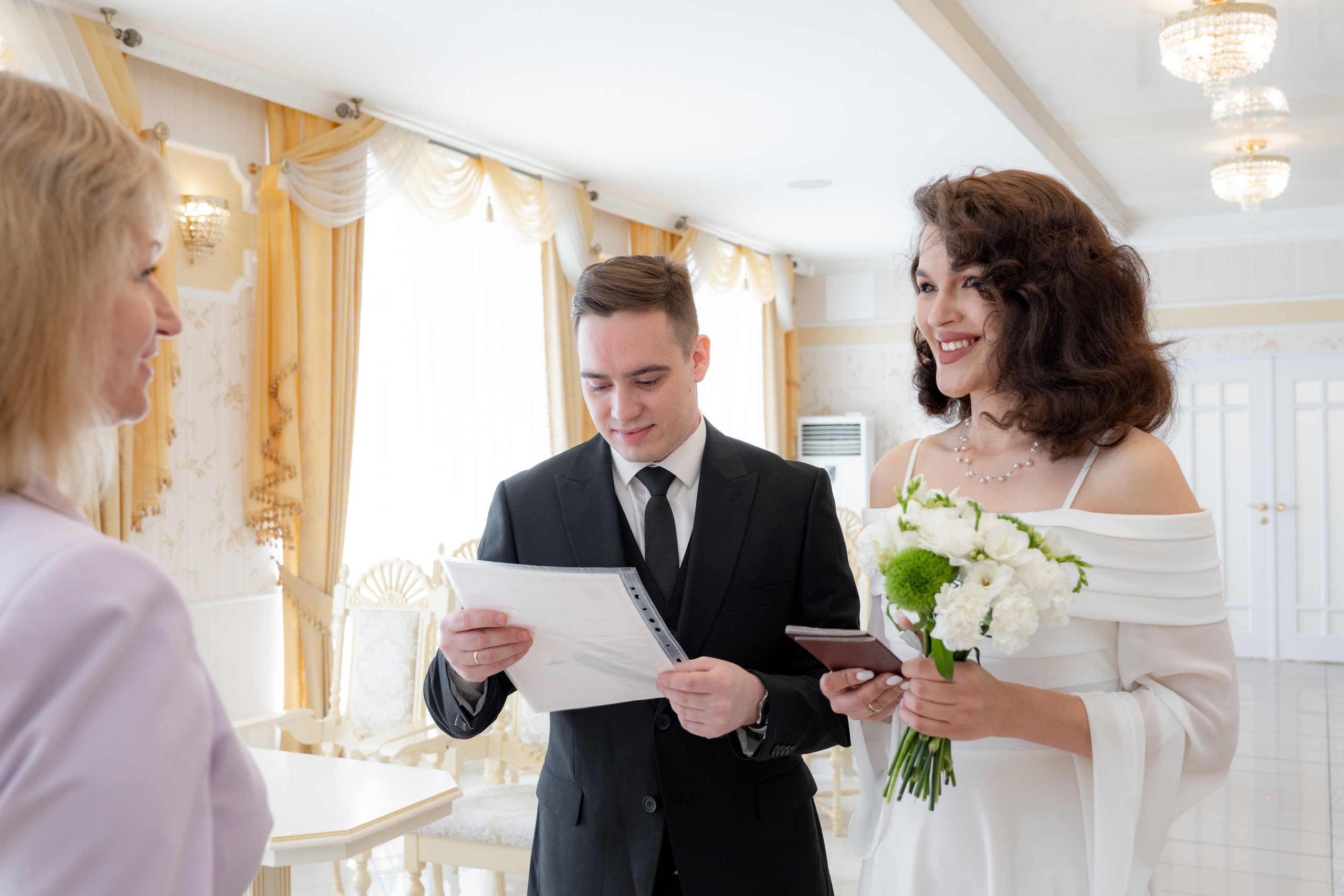 Жених и невеста получают свидетельство о браке на регистрации брака в загсе курортного района