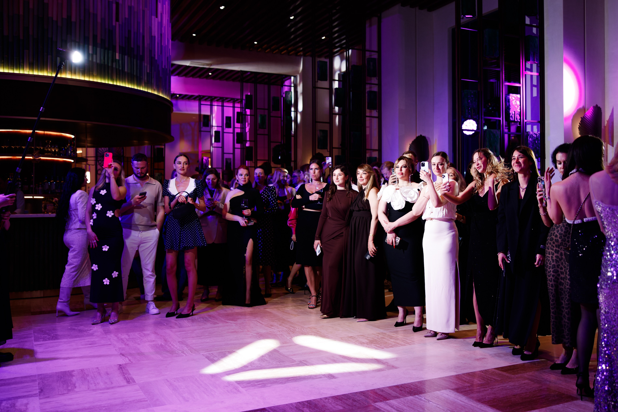 Танцпол: Гости в вечерних платьях танцуют в зале с современной мультимедийной подсветкой.