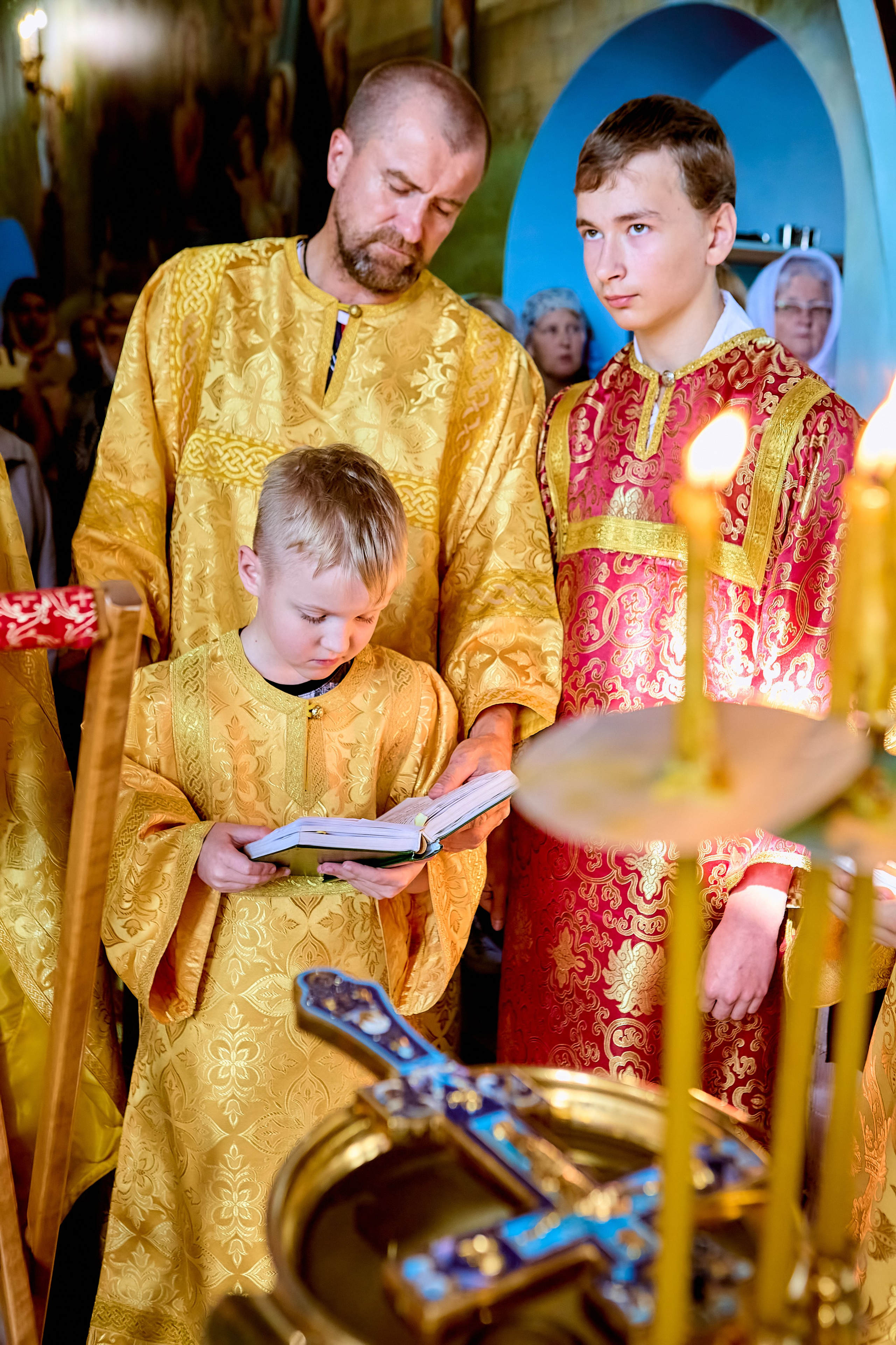 Алтарник маленький мальчик 8 лет с папой читают апостола на молебне освящения воды