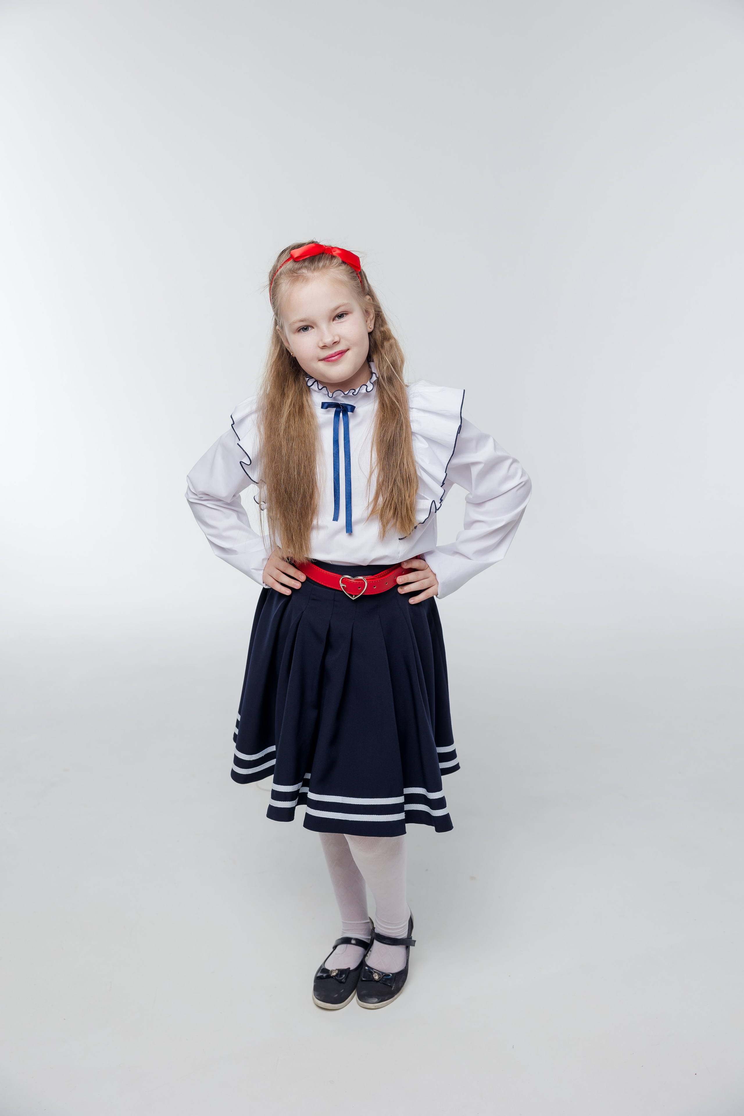 Портрет девочки в полный рост в студии в одежде с красными акцентами