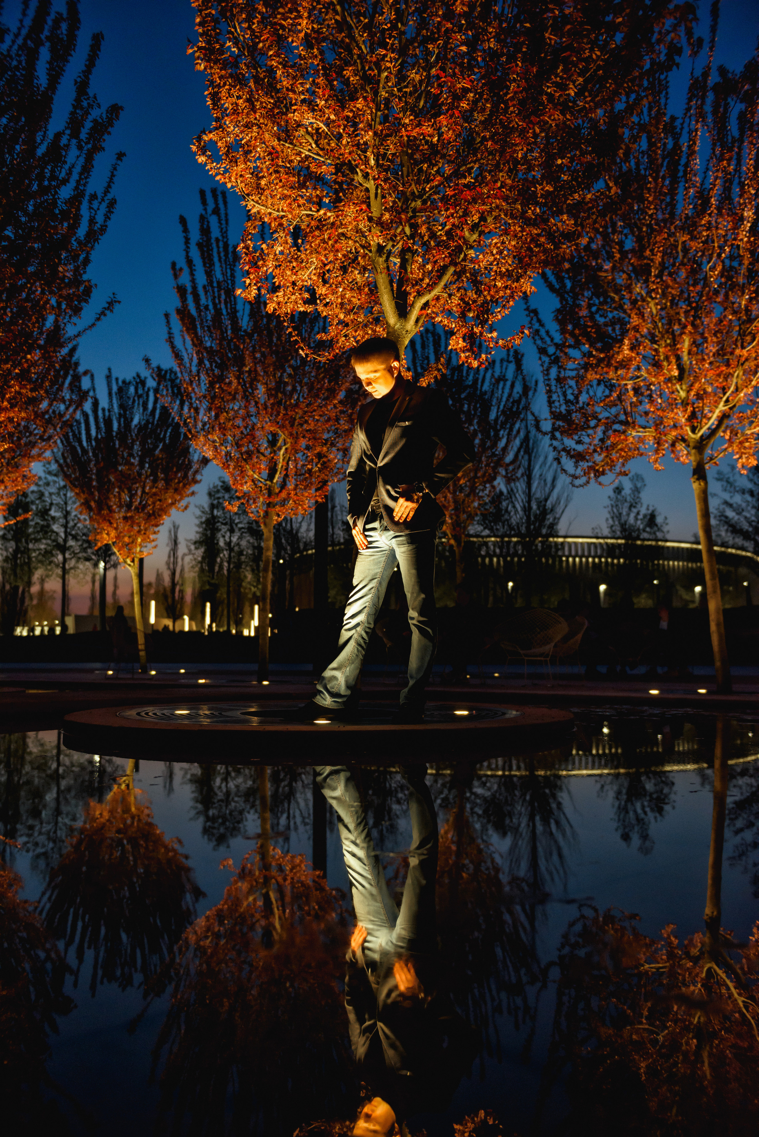Ночная фотосъемка в парке Галицкого, мужчина смотрит на свое отражение в воде