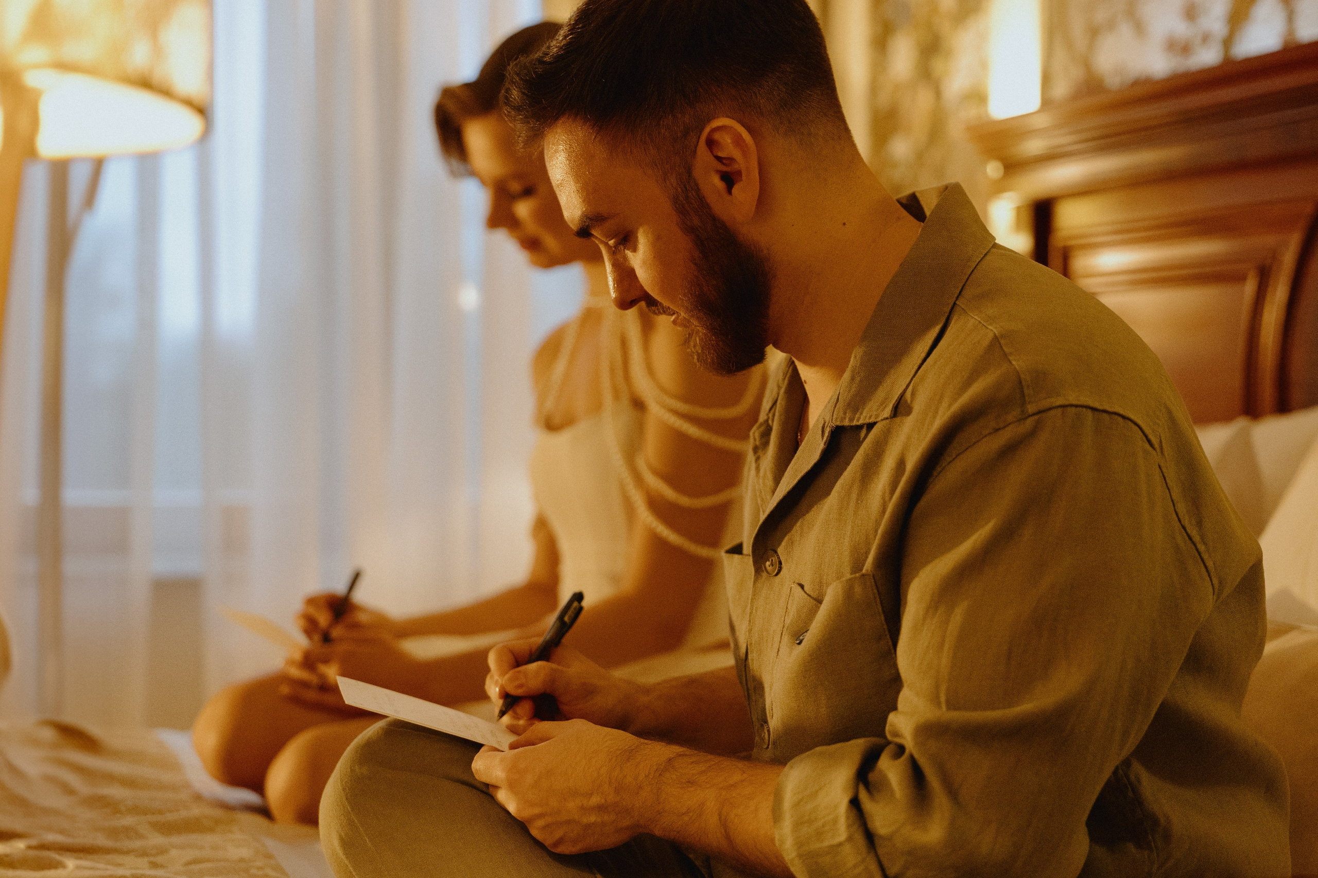 Жених и невеста сидят на кровати, смотрят друг на друга, держа в руках письма.