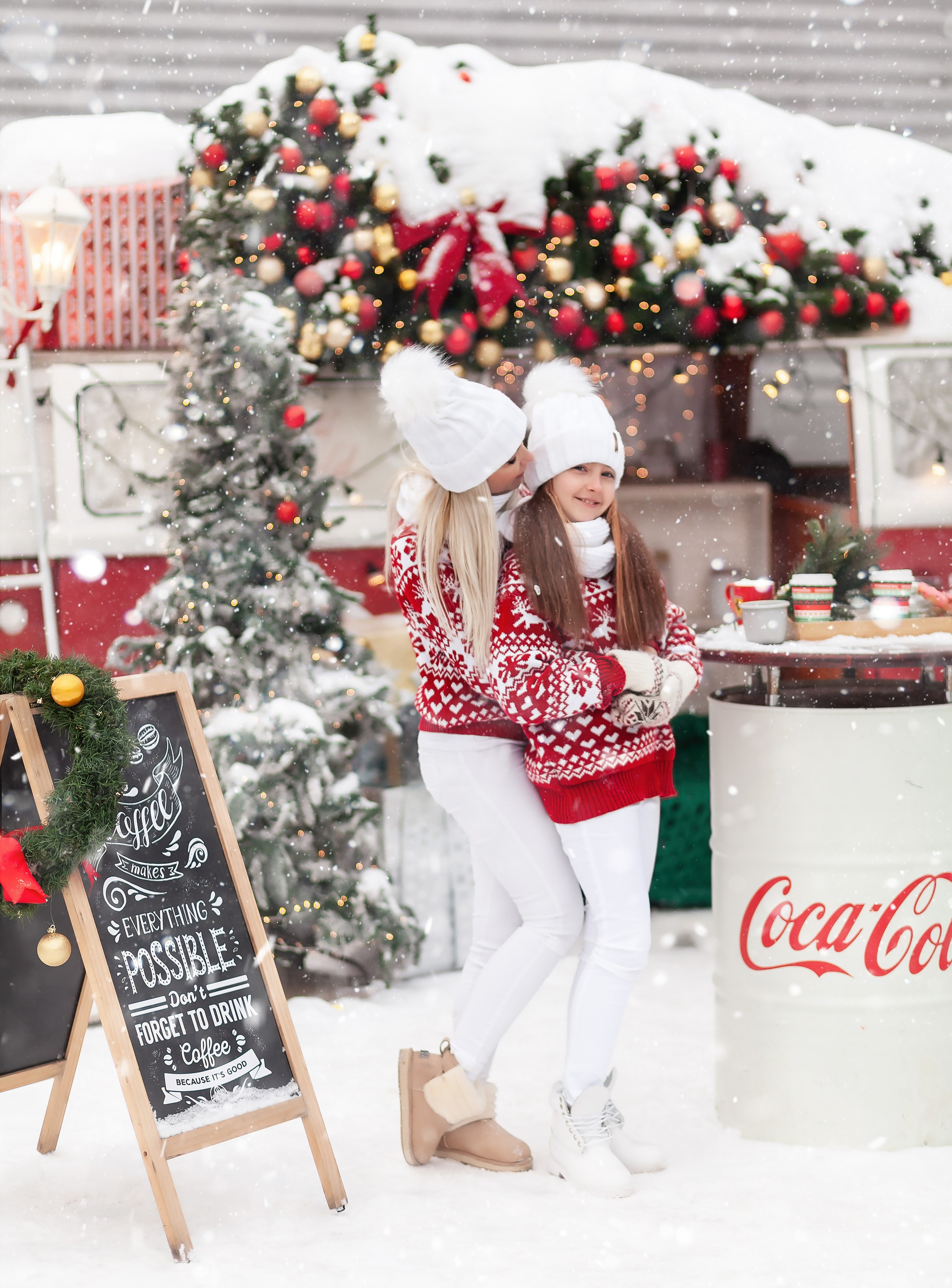 Мама и дочка обнимаются на фоне елки