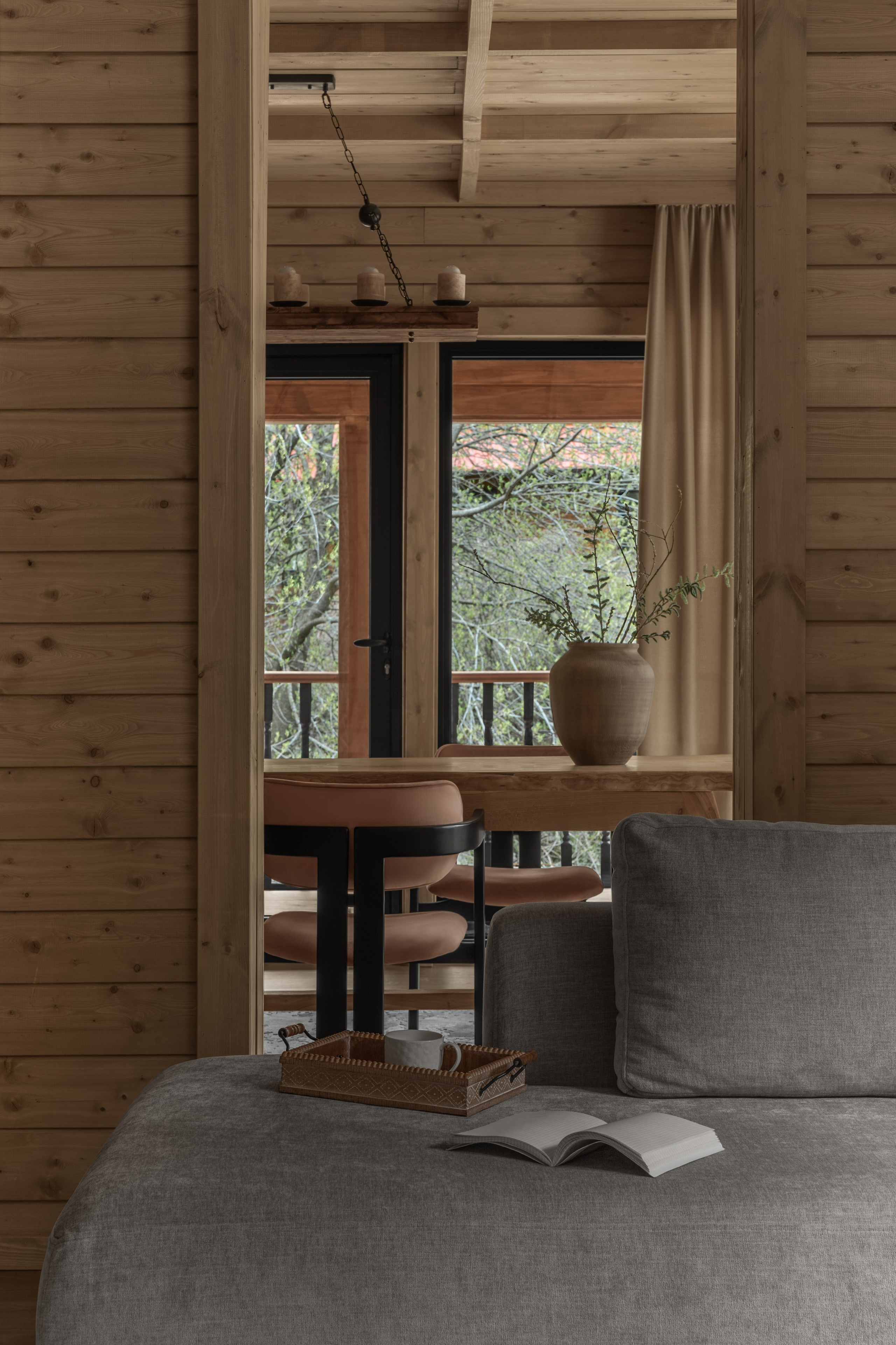 Фото интерьера деревянного домика в горах с видом из гостиной в обеденную зону.