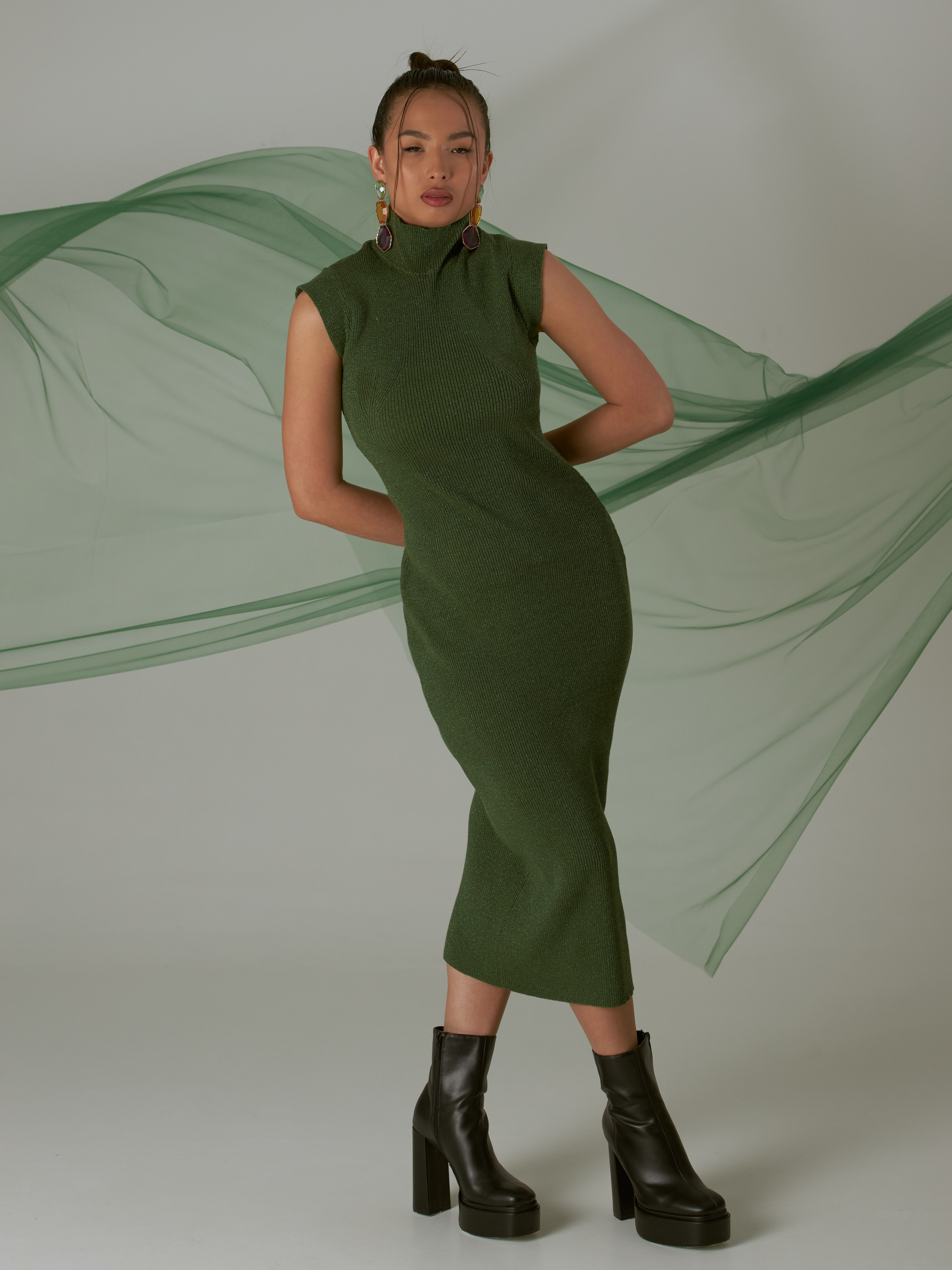 Портрет в полный прост девушки на белой циклораме в зеленом платье с фатином на заднем фоне